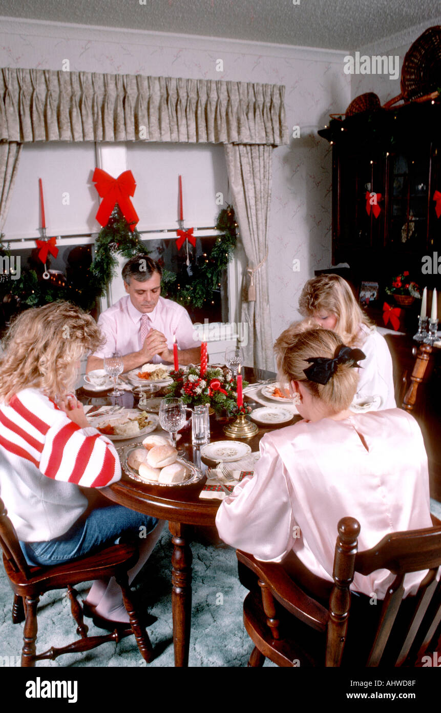 Familie sagt Gnade vor dem Essen in der Weihnachtszeit Stockfoto