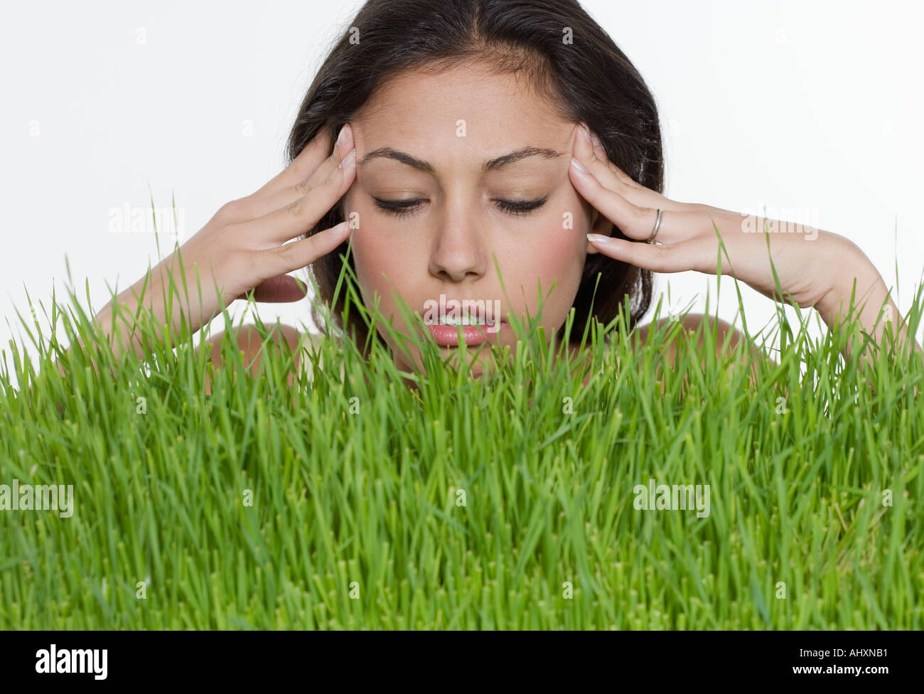 Betonte Frau mit langen Rasen Stockfoto