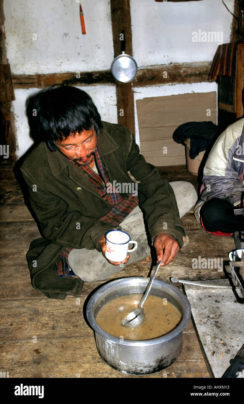 Bhutan Bhutan Paro Mann Gießen Yak Buttertee in Küche Stockfoto
