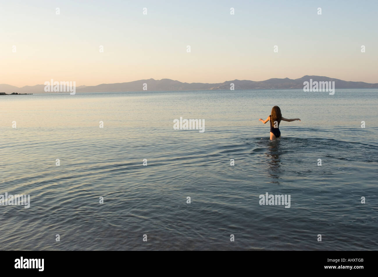 junge Mädchen gehen zum Schwimmen bei Sonnenuntergang in der Mittelmeer-Costa Brava-Spanien Stockfoto