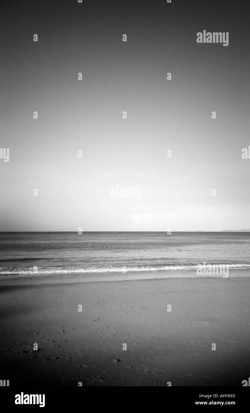 schwarz / weiß Bild mit Blick auf eine ruhige See an einem Strand in cornwall Stockfoto
