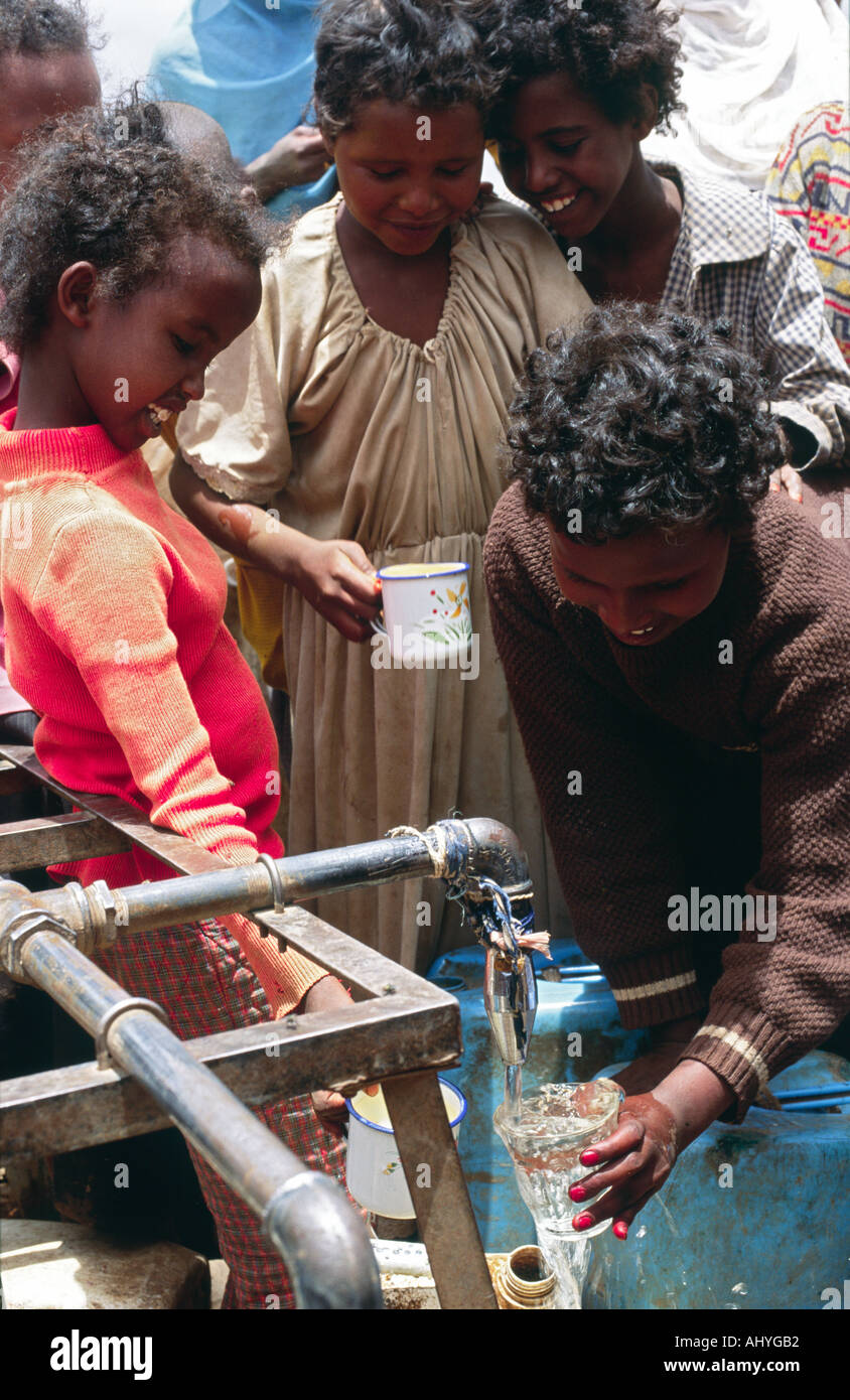 Somalische Flüchtlingskinder, die Trinkwasser an einem kommunalen Wasserhahn in Kebrebeyah, Ostäthiopien, schöpfen Stockfoto