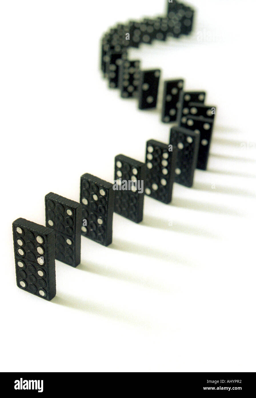 Eine geschwungene Reihe von Dominosteinen auf weißem Hintergrund Stockfoto