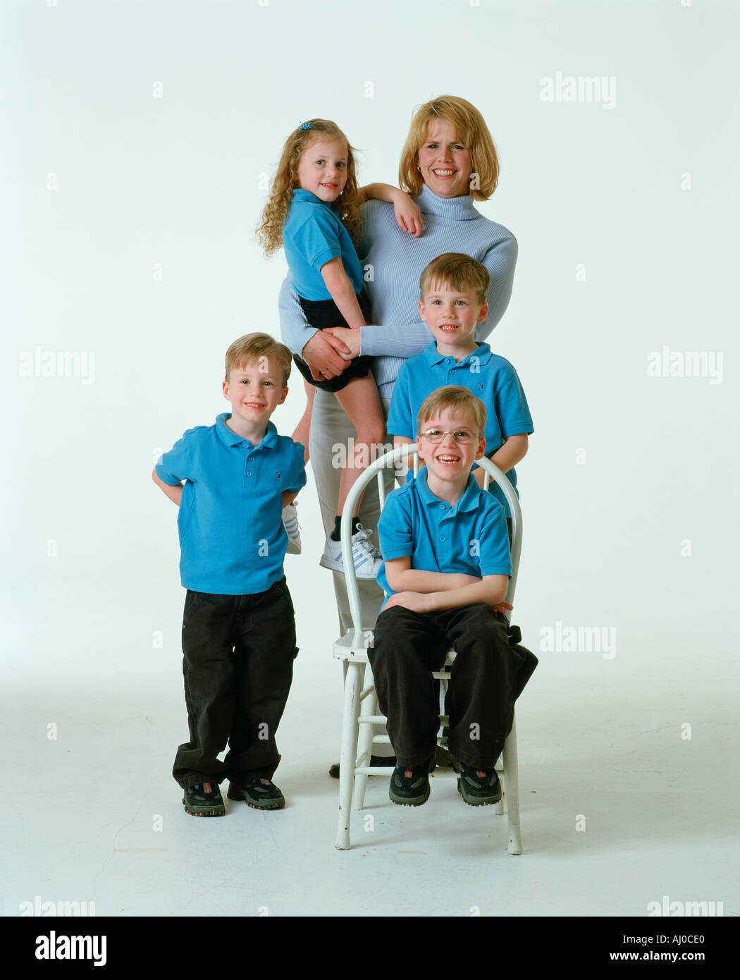 Studio-Porträt einer Mutter mit ihrem Vierlinge drei jungen und ein Mädchen tragen die Kinder passenden blaue Hemden Stockfoto
