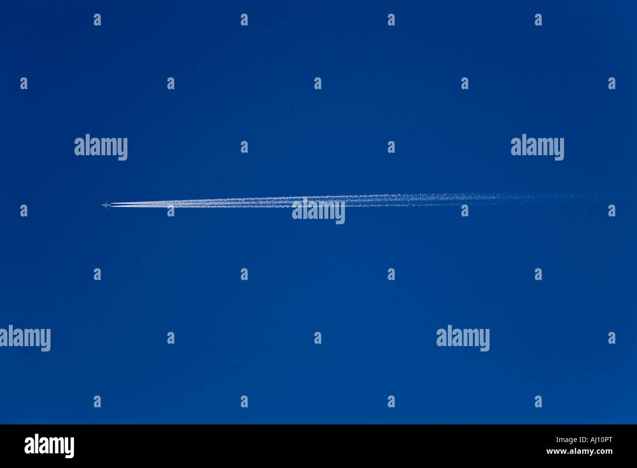 JET FLIEGEN HOCH VOR BLAUEM HIMMEL MIT EINEM DAMPF-TRAIL Stockfoto