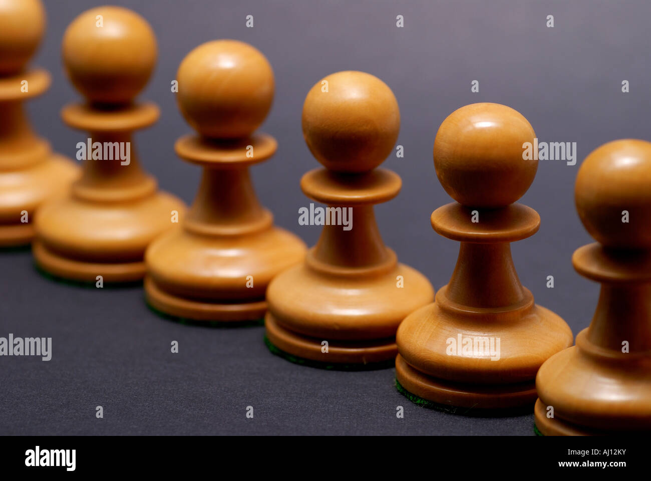 Schach Schachfiguren in einer Linie gegen einen schwarzen Papierhintergrund. Stockfoto