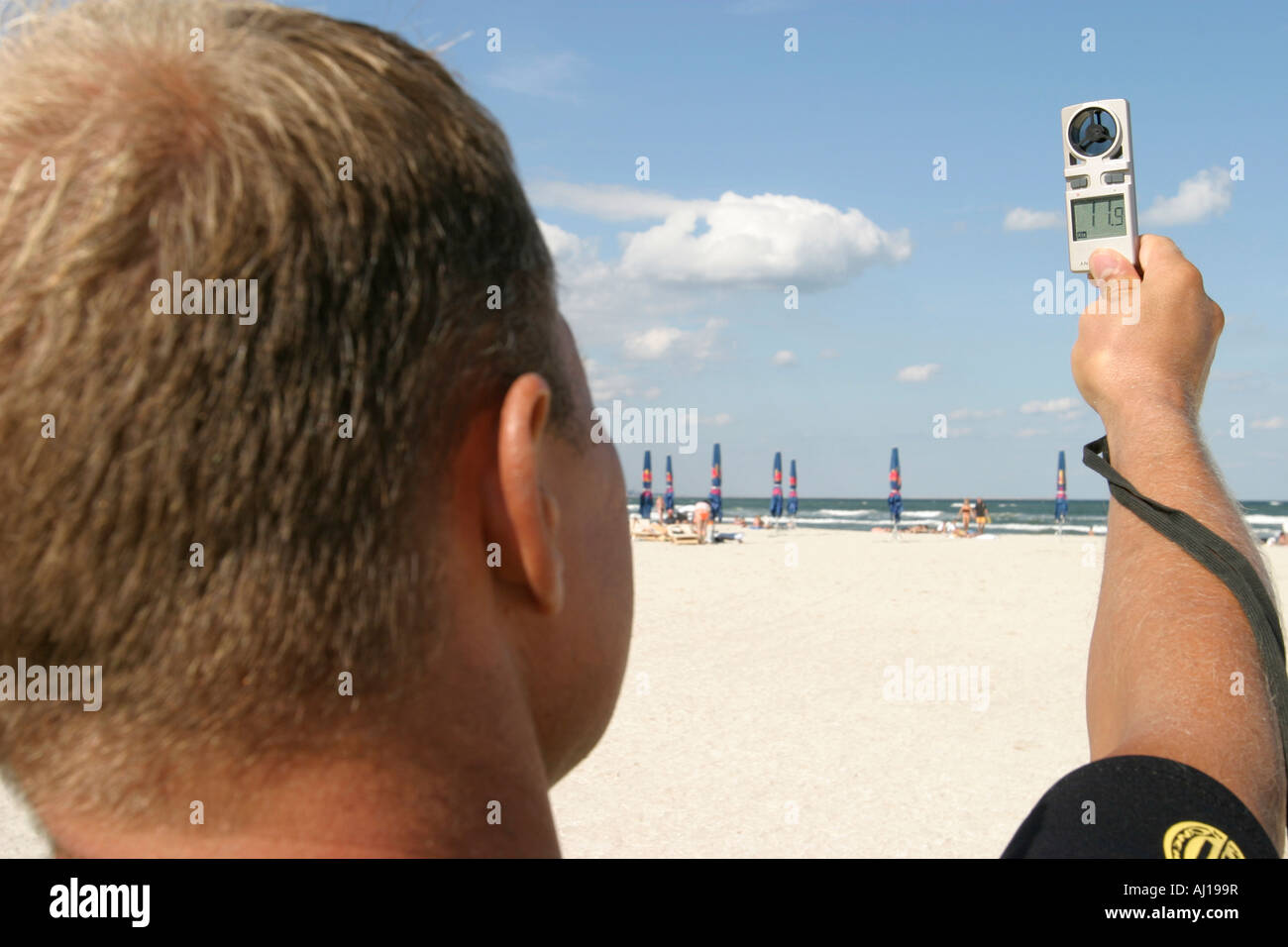Mann hält ein Anemometer, Messung der Windgeschwindigkeit Stockfoto