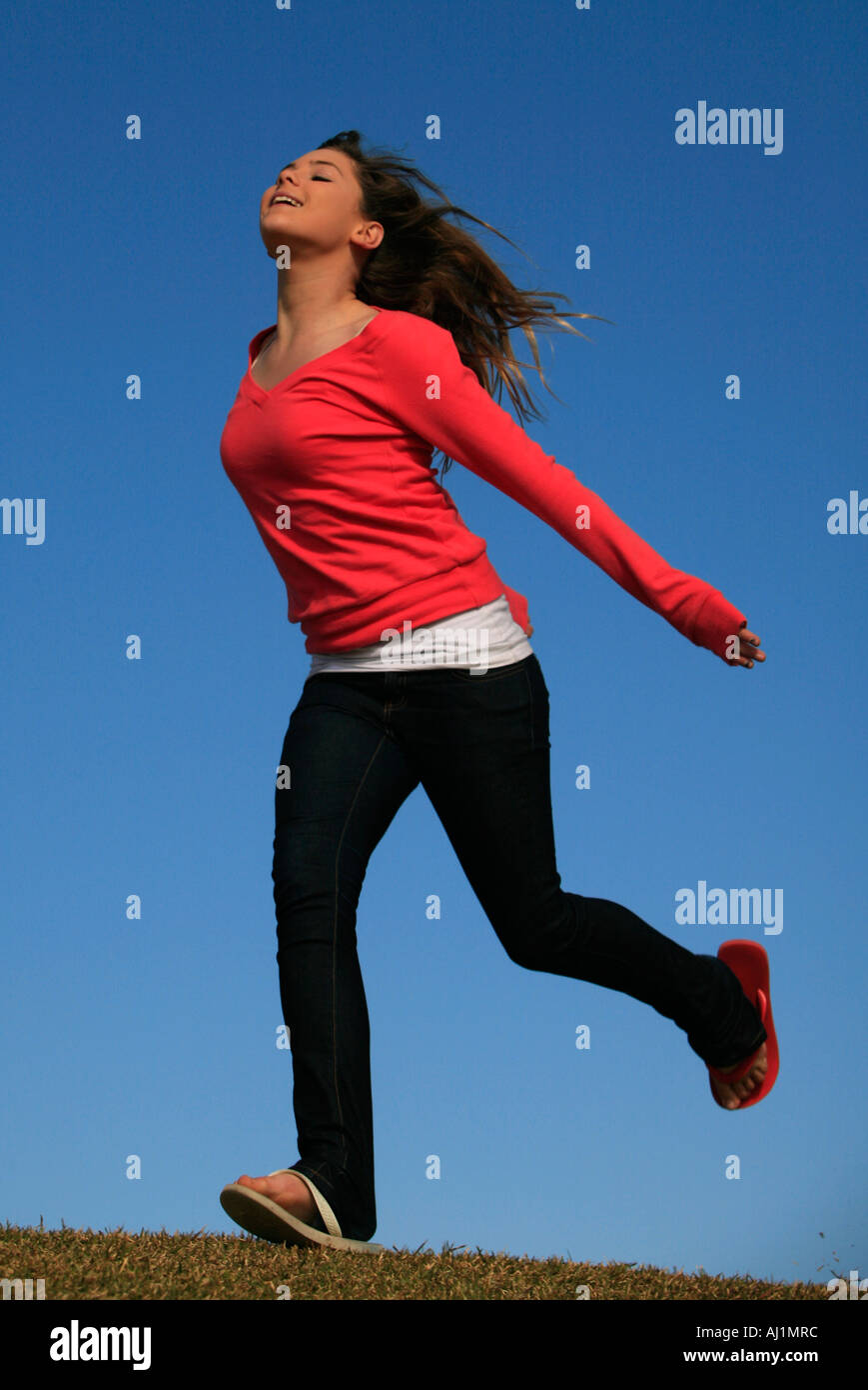 Eine Mädchen erklärt, daß Freiheit rennt gegen ein strahlend blauer Himmel Stockfoto