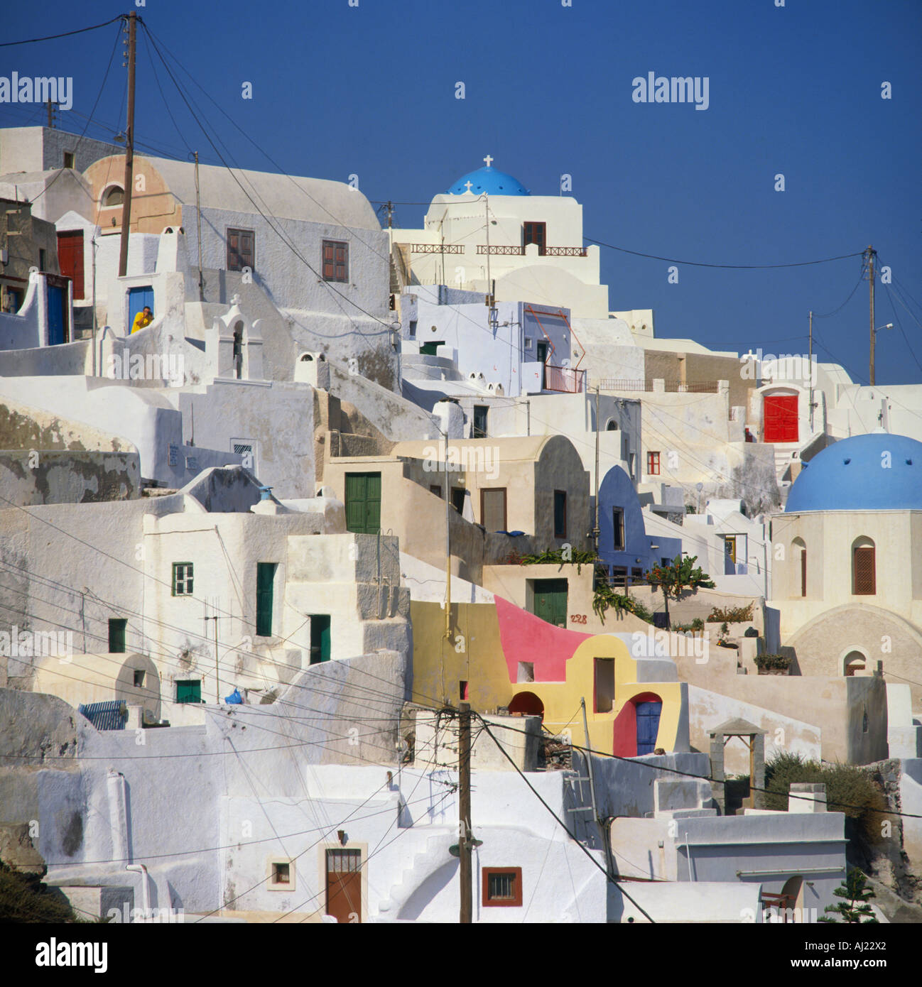 Weiß und Pastell farbigen Häuser gruppierten gegen ein strahlend blauer Himmel am Dorf Oia auf Santorin Insel der griechischen Inseln Griechenland Stockfoto