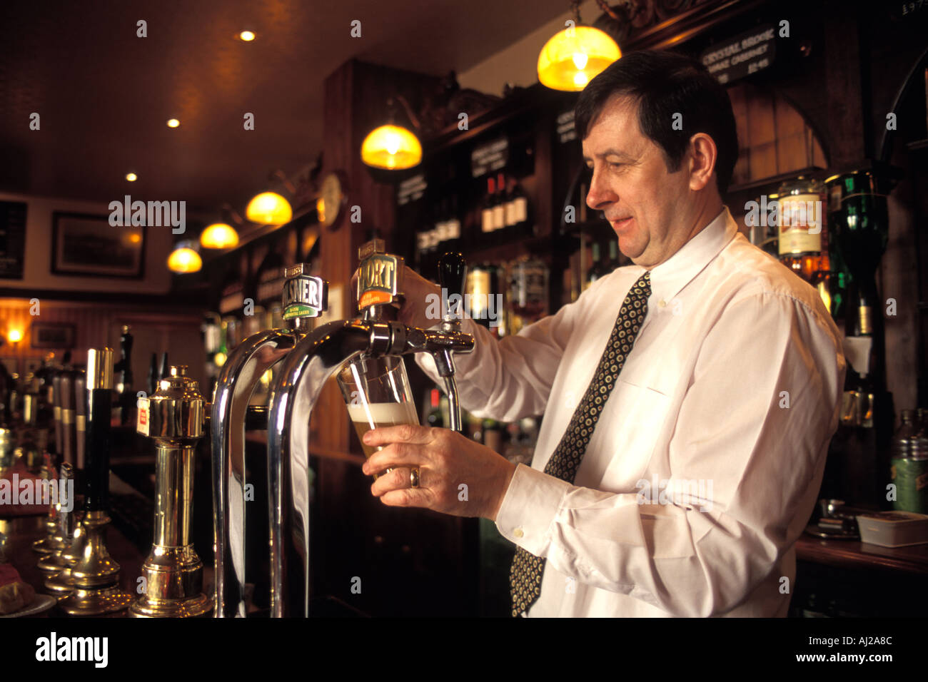 Pub Vermieter gießt ein Pint Lager, London, UK Stockfoto