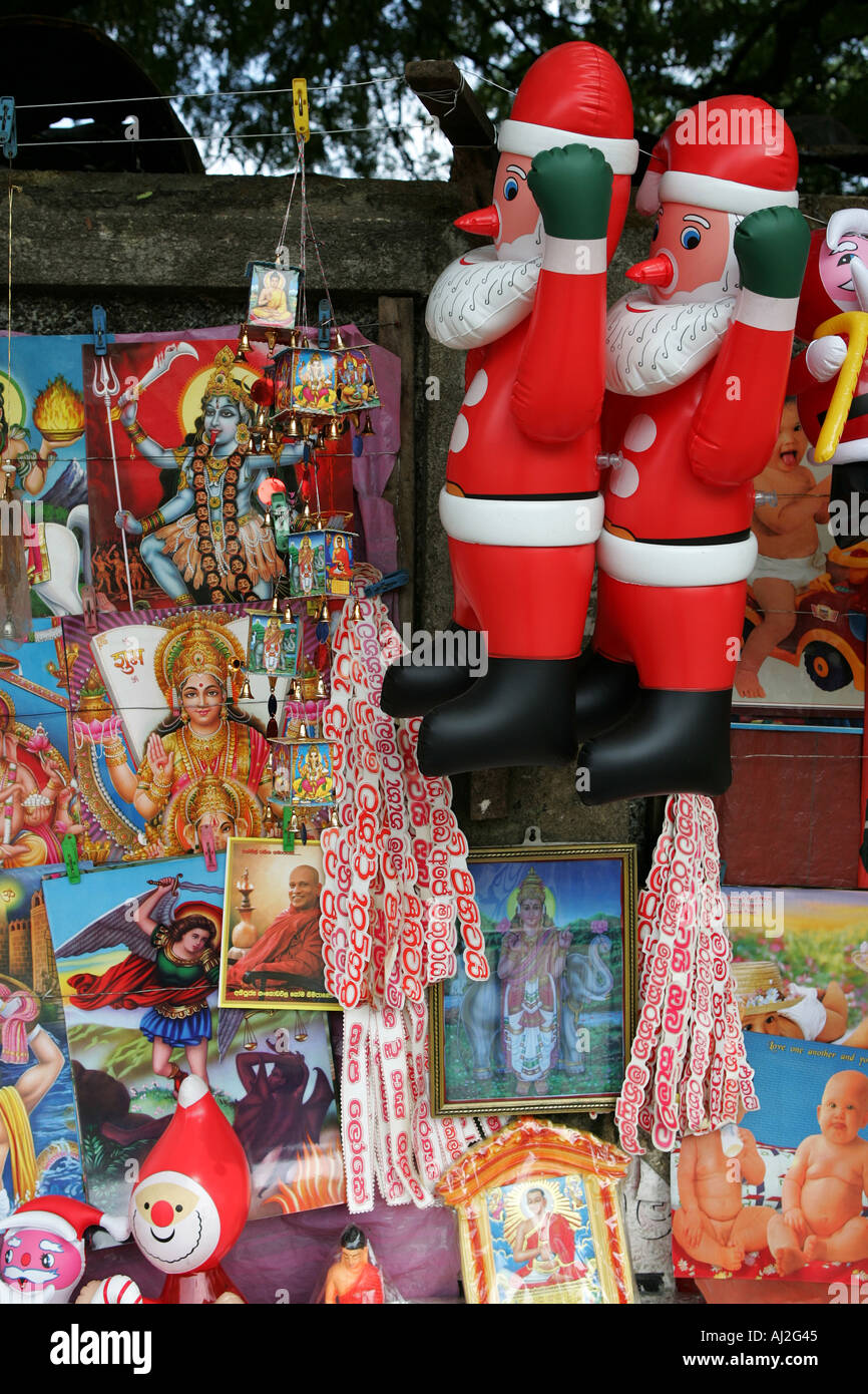 Mann verkauft Santa Figuren während Weihnachten Zeit neben religiösen  Bildern aus dem Buddhismus und Hinduismus in Ratnapura, Sri Lanka  Stockfotografie - Alamy