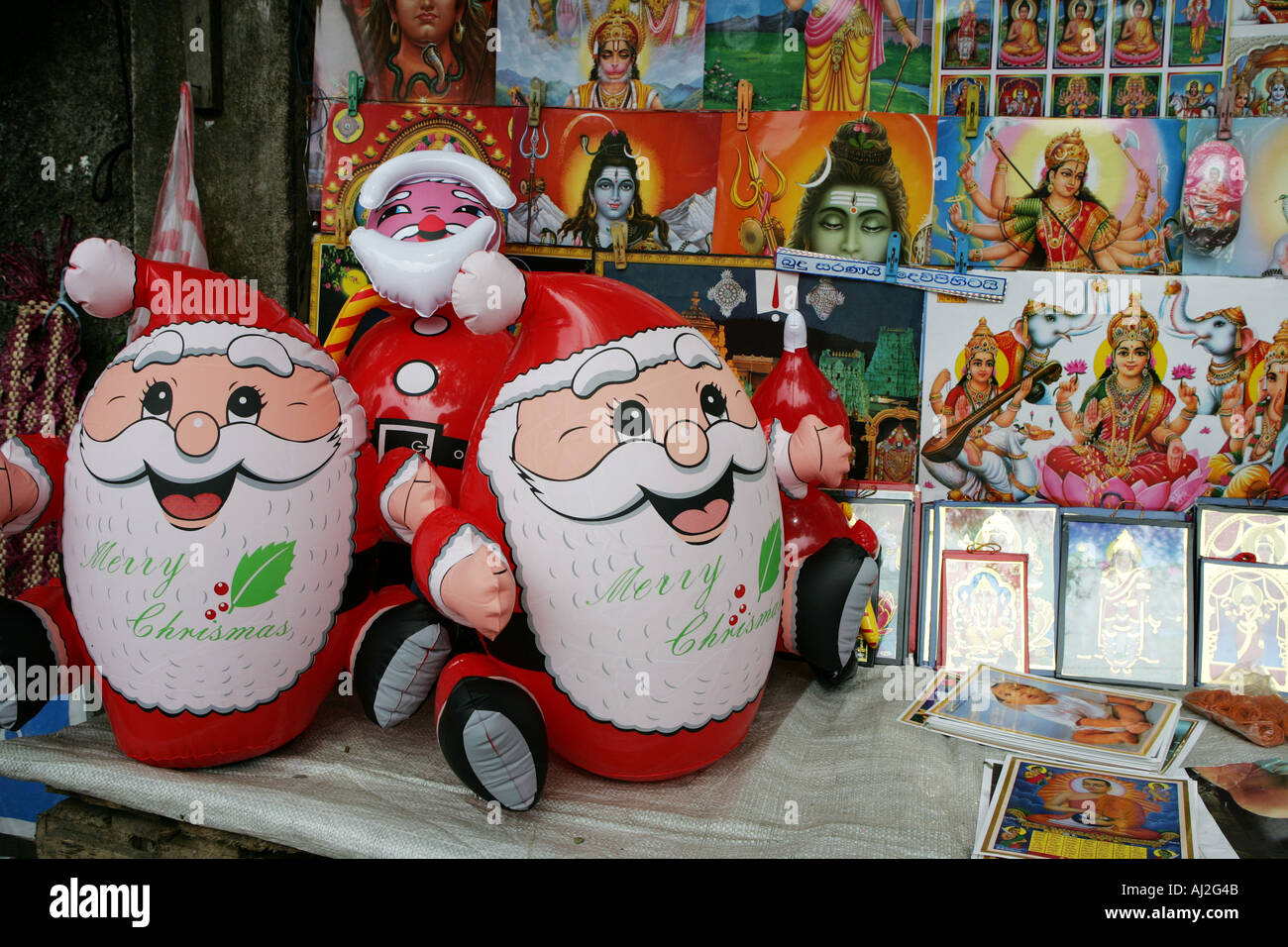 Mann verkauft Santa Figuren während Weihnachten Zeit neben religiösen  Bildern aus dem Buddhismus und Hinduismus in Ratnapura, Sri Lanka  Stockfotografie - Alamy