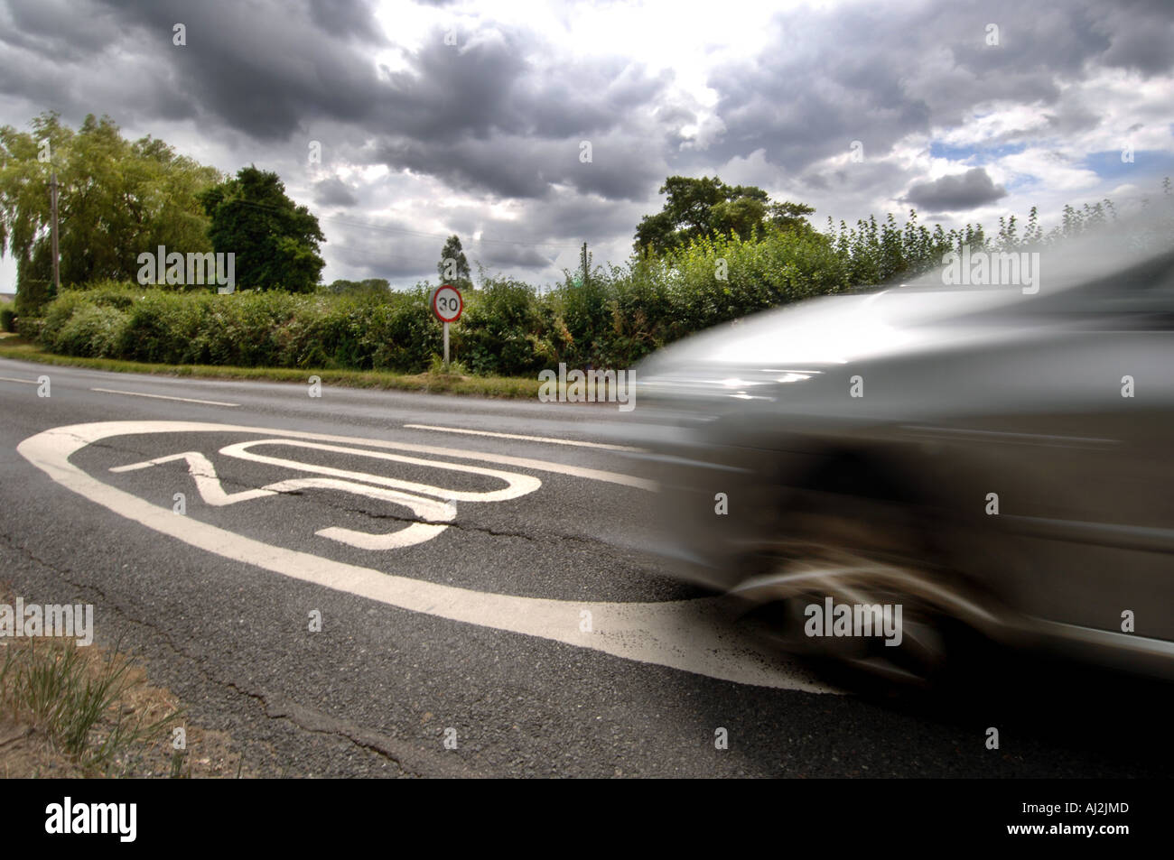 Raser auf einer Landstraße in Ringmer East Sussex England UK Pässe eine 30 km/h Meilen pro Stunde Geschwindigkeit Zeichen auf die Straße gemalt Stockfoto