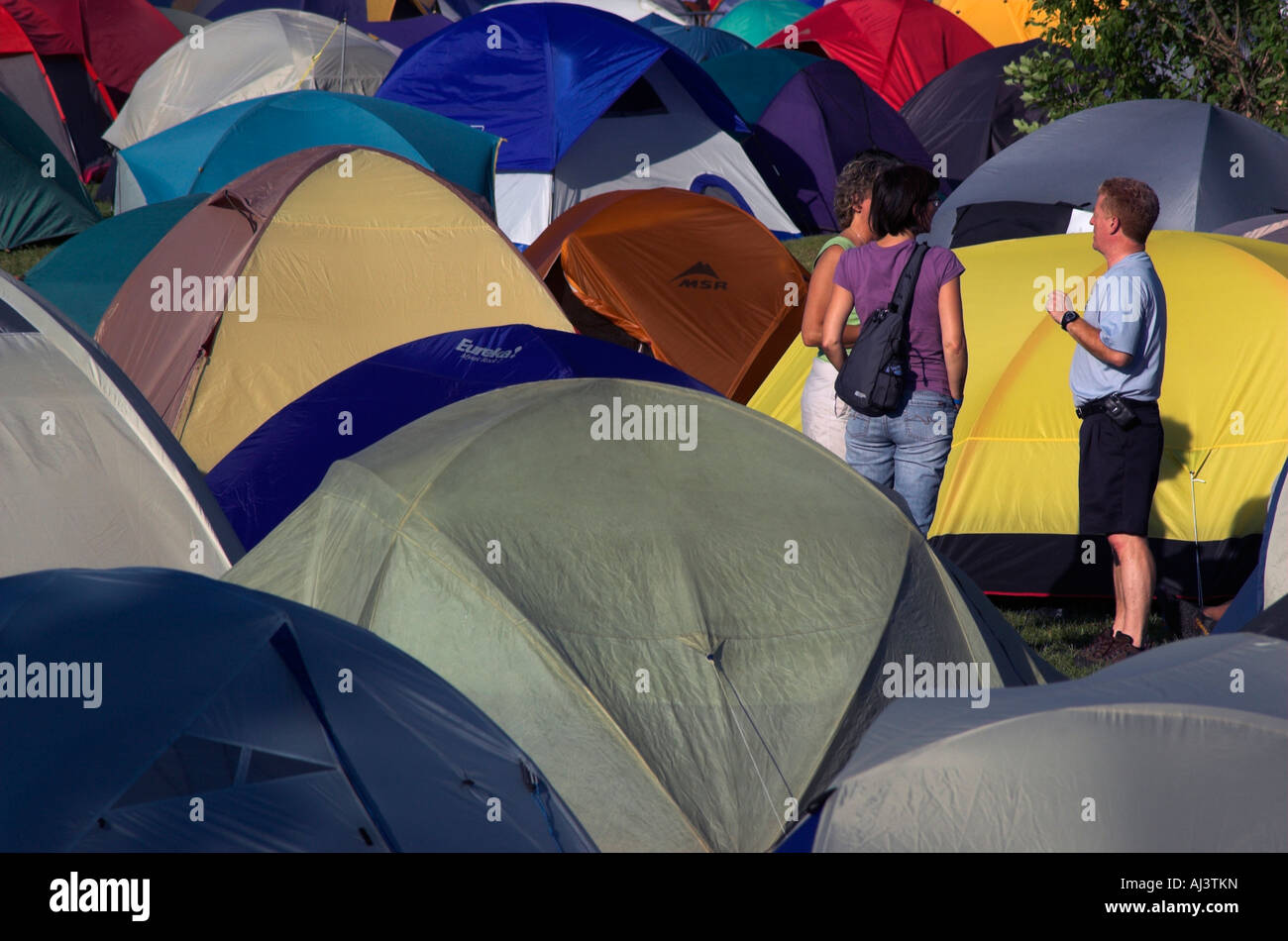 Zwei Menschen unterhalten sich in einem dicht gepackten Campingplatz Stockfoto