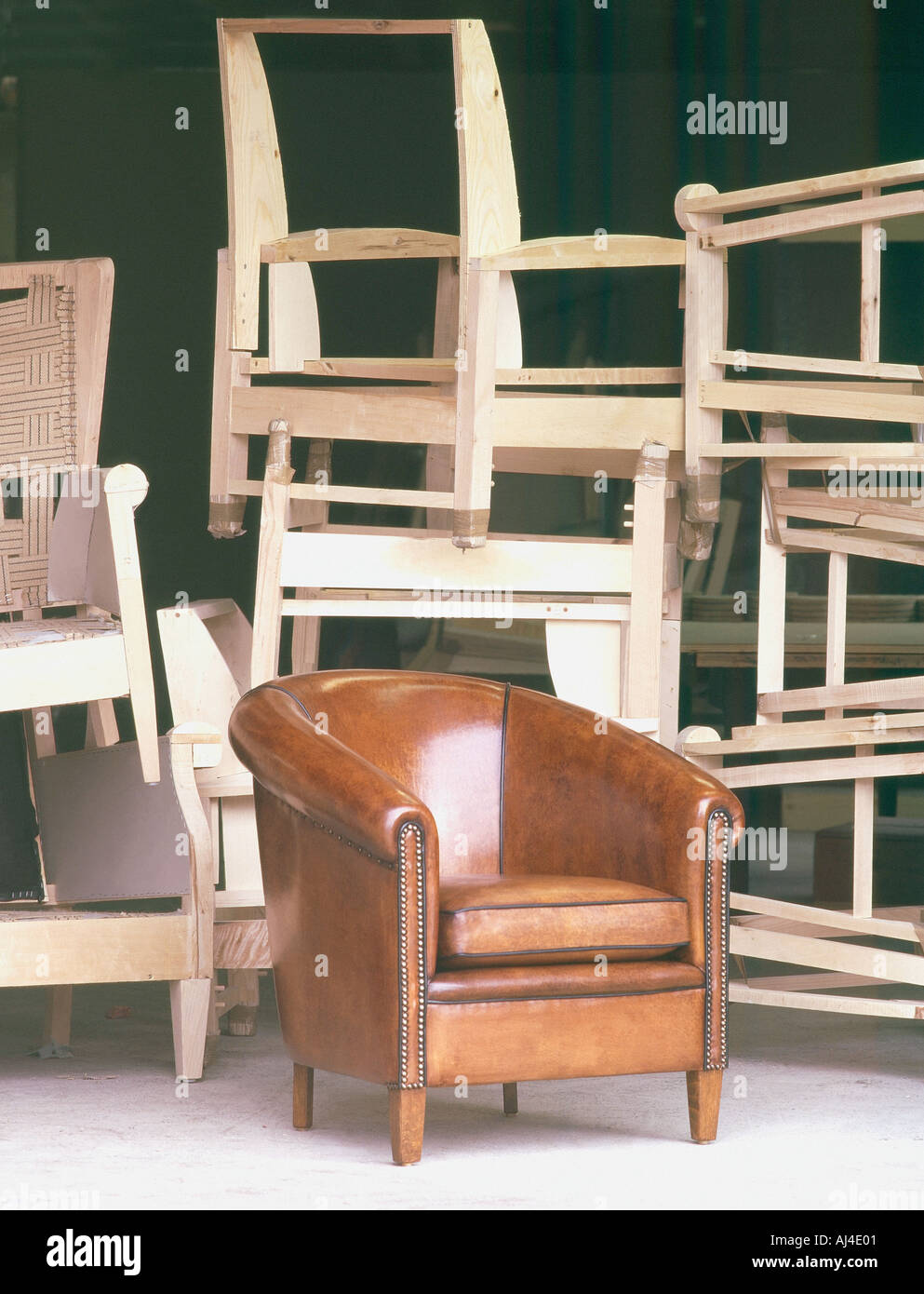 Leder Lammfell Clubchair vor einen Haufen von handgefertigten Holzstuhl frames Stockfoto