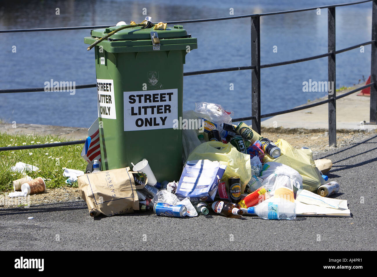Wurf stapelten sich neben einer Straße nur grüne Wheelie Abfallbehälter durch einen Zaun auf der Pier Galway Stadt Stockfoto