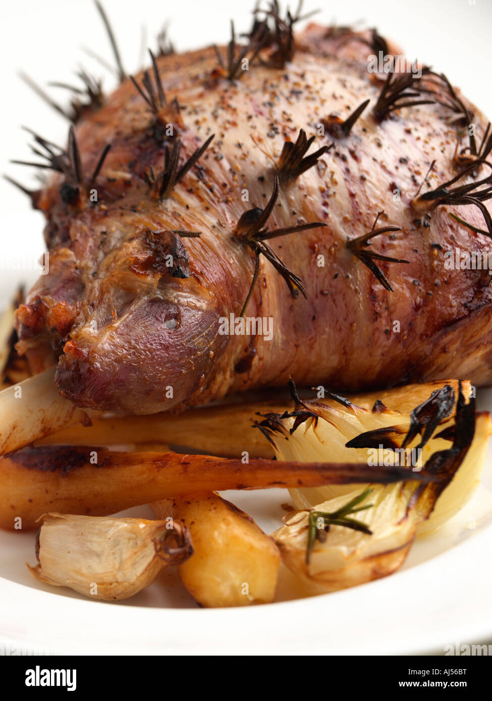 Ganze gebratene Lammkeule mit gebratenen Pastinaken Zwiebeln und Knoblauch Stockfoto