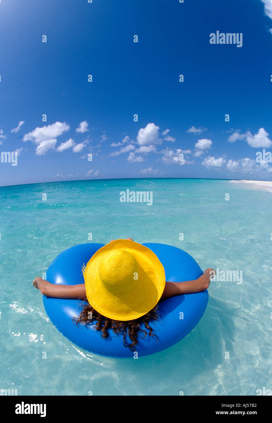 Turks und Caicos Provo-Frau im gelben Hut in blauen Schlauch schwimmt im Ozean Stockfoto