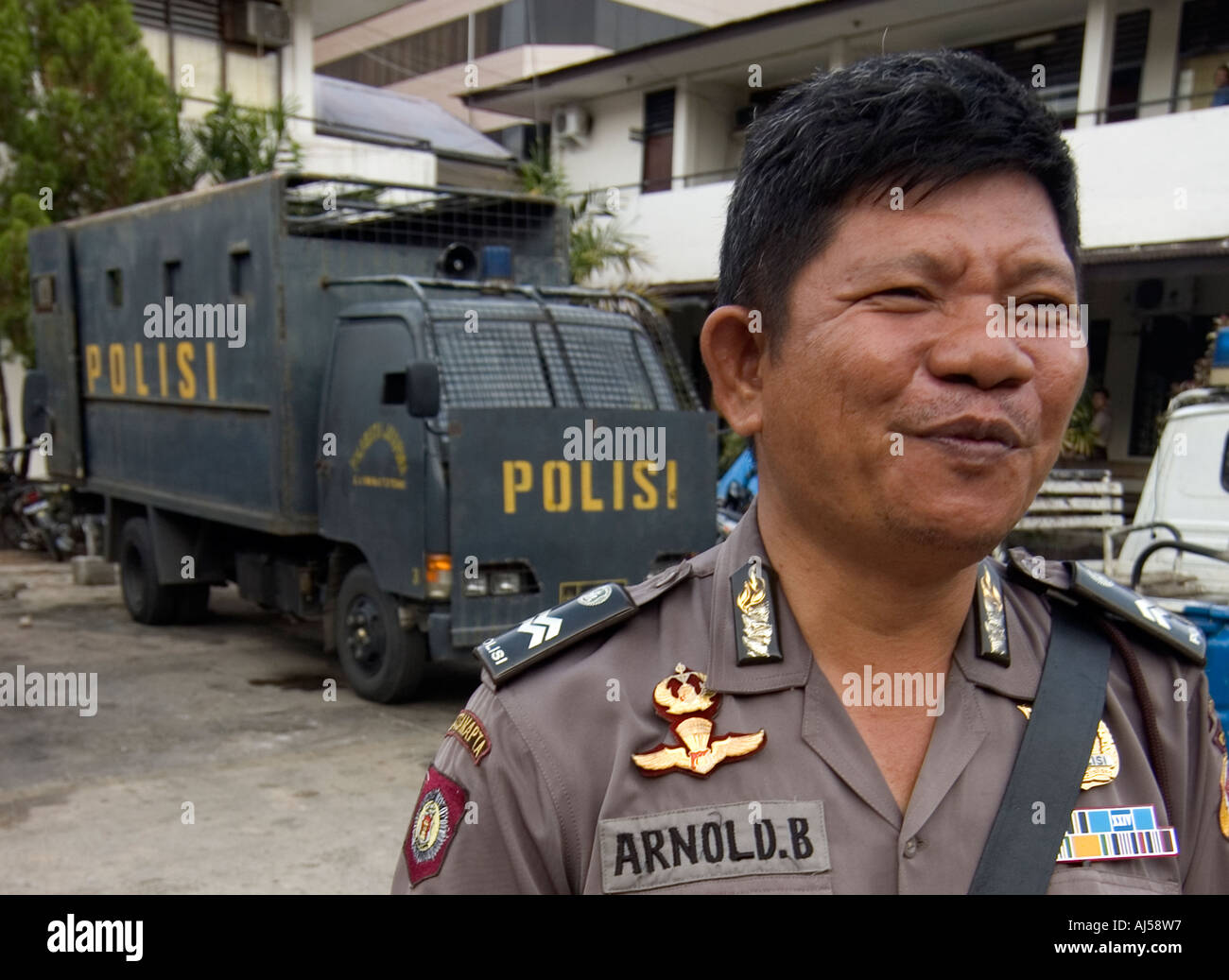 Porträt der indonesischen Polizei Offizier in Jayapura, mit Anti-Aufruhr-LKW in den Hintergrund, West-Papua, Indonesien Stockfoto