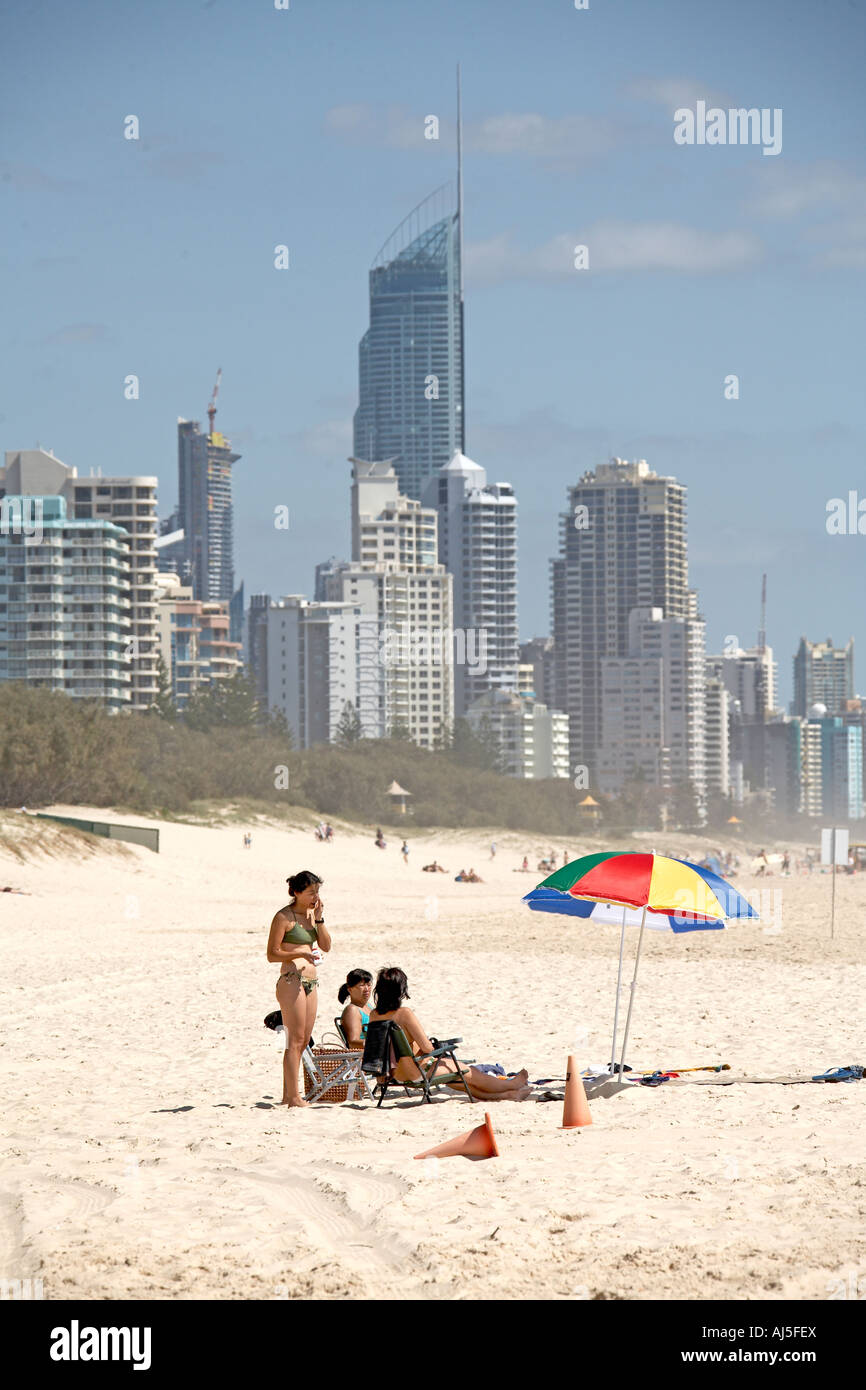 Appartment oder Hotel Einheit Hochhaus Gebäude und Strand mit Menschen Sonnenbaden mit Regenschirm in Surfers Paradise Queensland QLD Stockfoto
