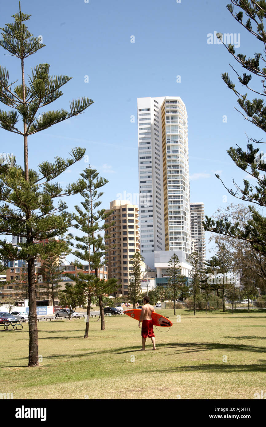 Hoch moderne Wohnung der Einheit Hochhäuser mit Surfer Mann trägt Board in Surfers Paradise Queensland QLD Australien Stockfoto