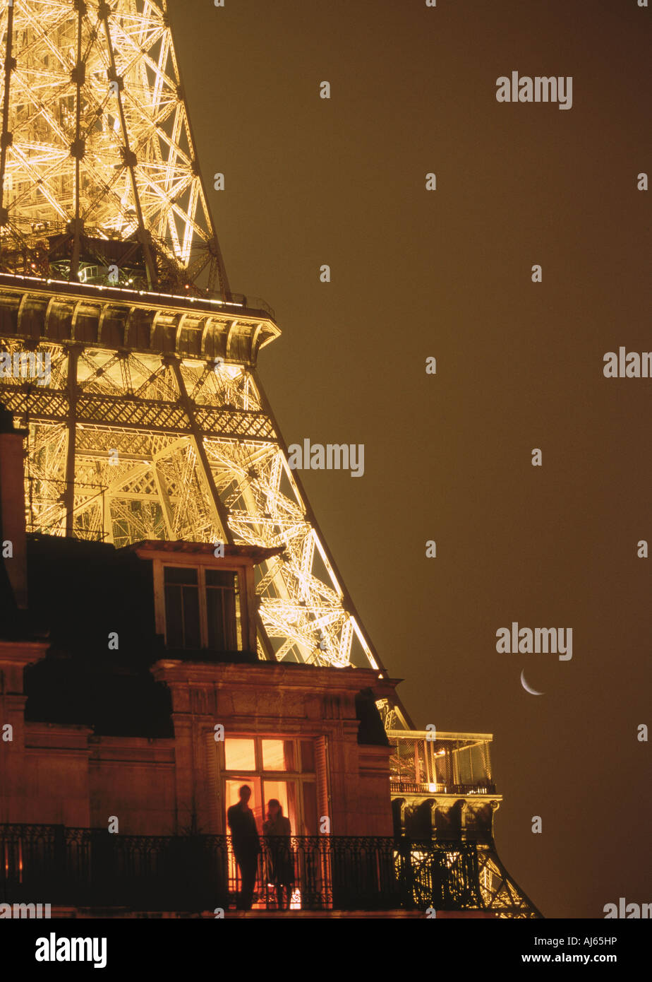 Paar auf Balkon unter Sternenhimmel und Halbmond in der Nähe von Eiffelturm in Paris Stockfoto