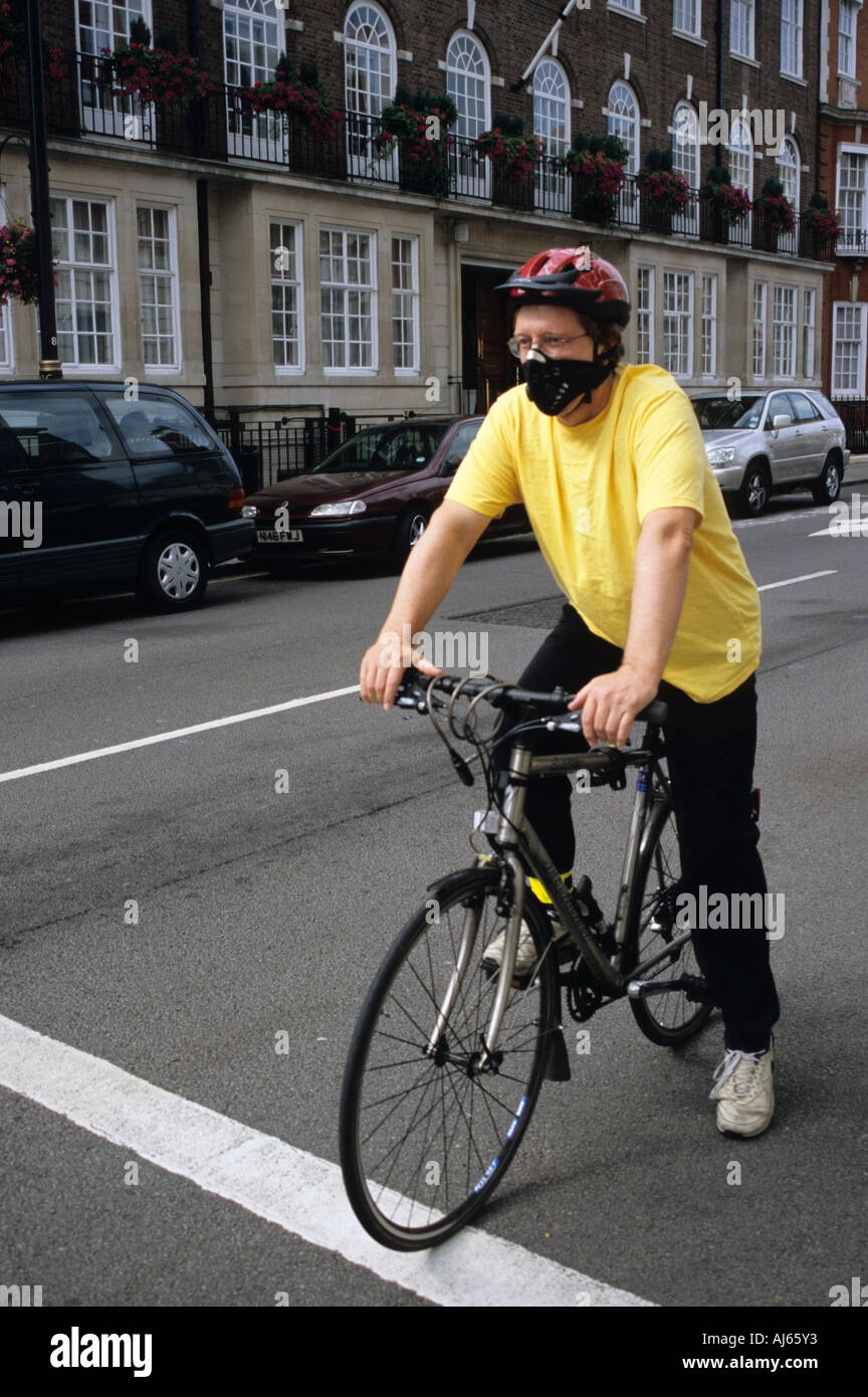 Radfahrer mit emissionsmindernden Maske London Stockfoto