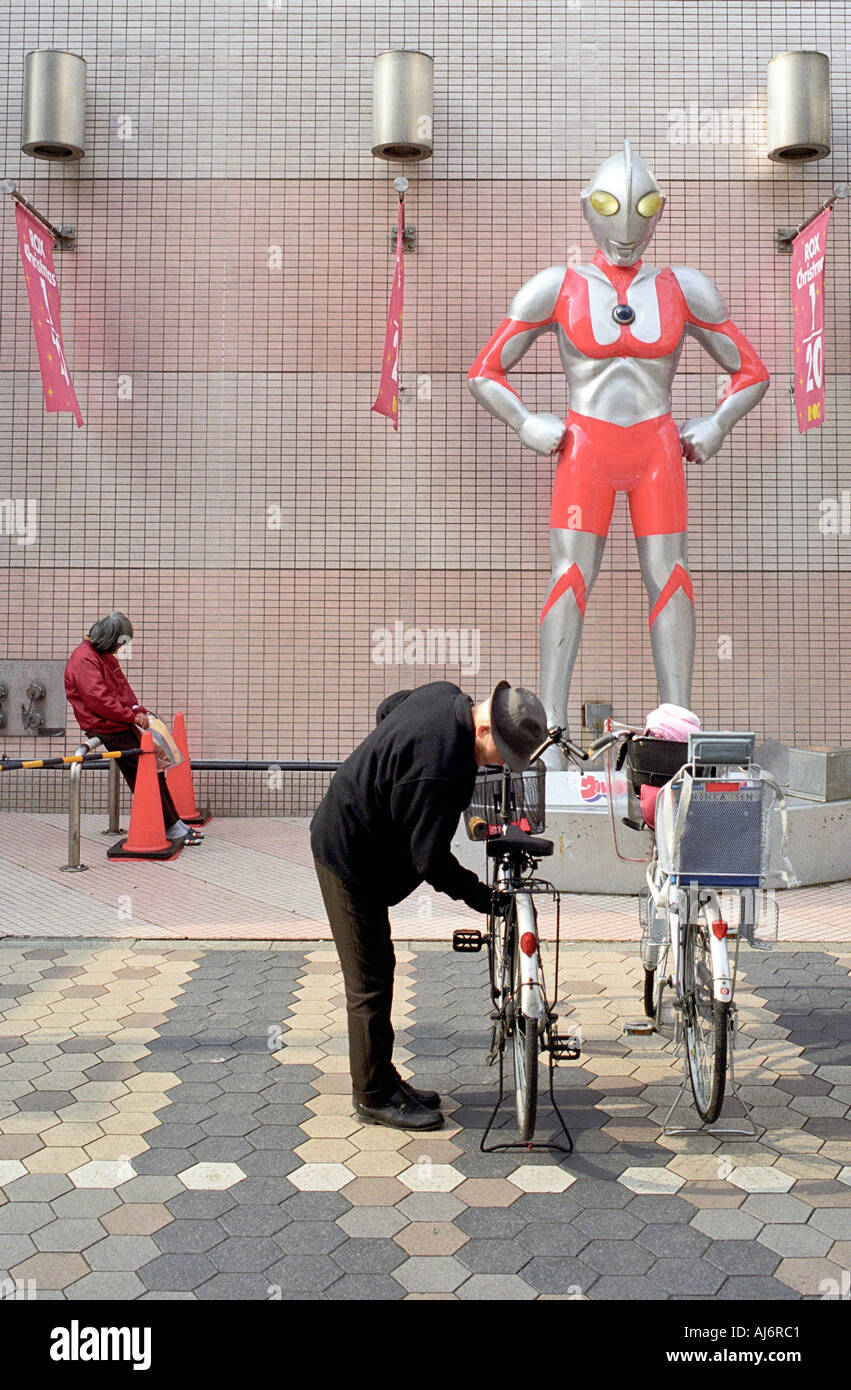 Ein Mann sichert sein Fahrrad außerhalb eines Kaufhauses in Tokio Stockfoto