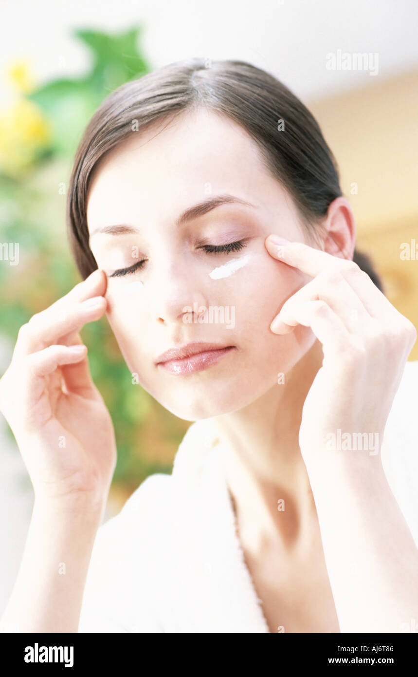 Junge Frau Kosmetika im Gesicht anwenden. Stockfoto