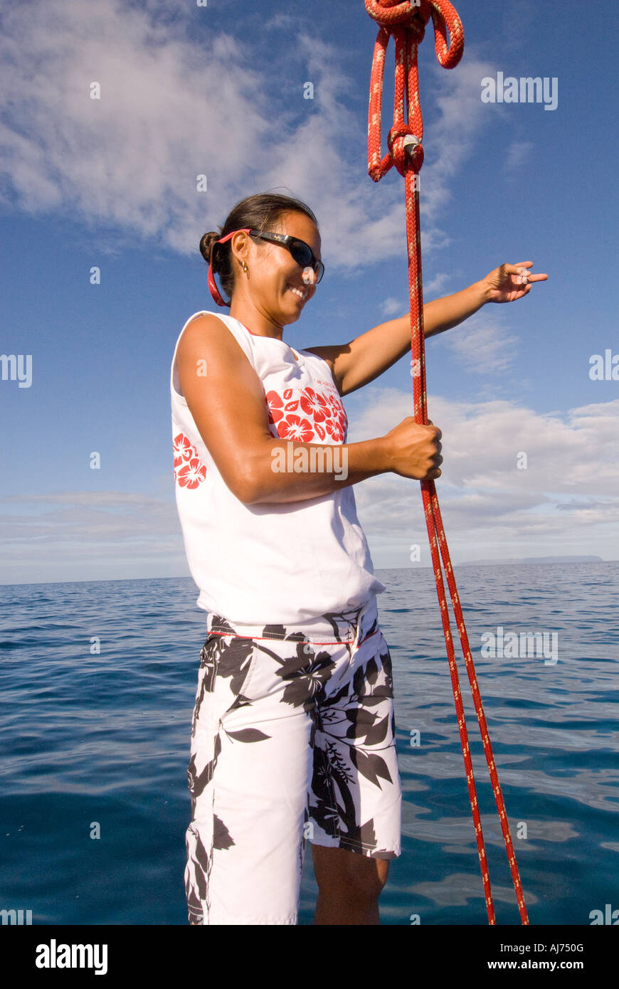 Hawaii Kauai Segeln weibliche Deck Hand zeigt in Richtung s-Delphine schwimmen neben dem Boot Stockfoto