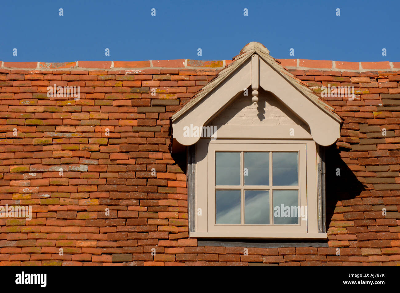 Traditionellen Stil gefliest Dach mit Dachgaube gesetzt vor blauem Himmel. Sidlesham, in der Nähe von Selsey. Foto von Jim Holden. Stockfoto