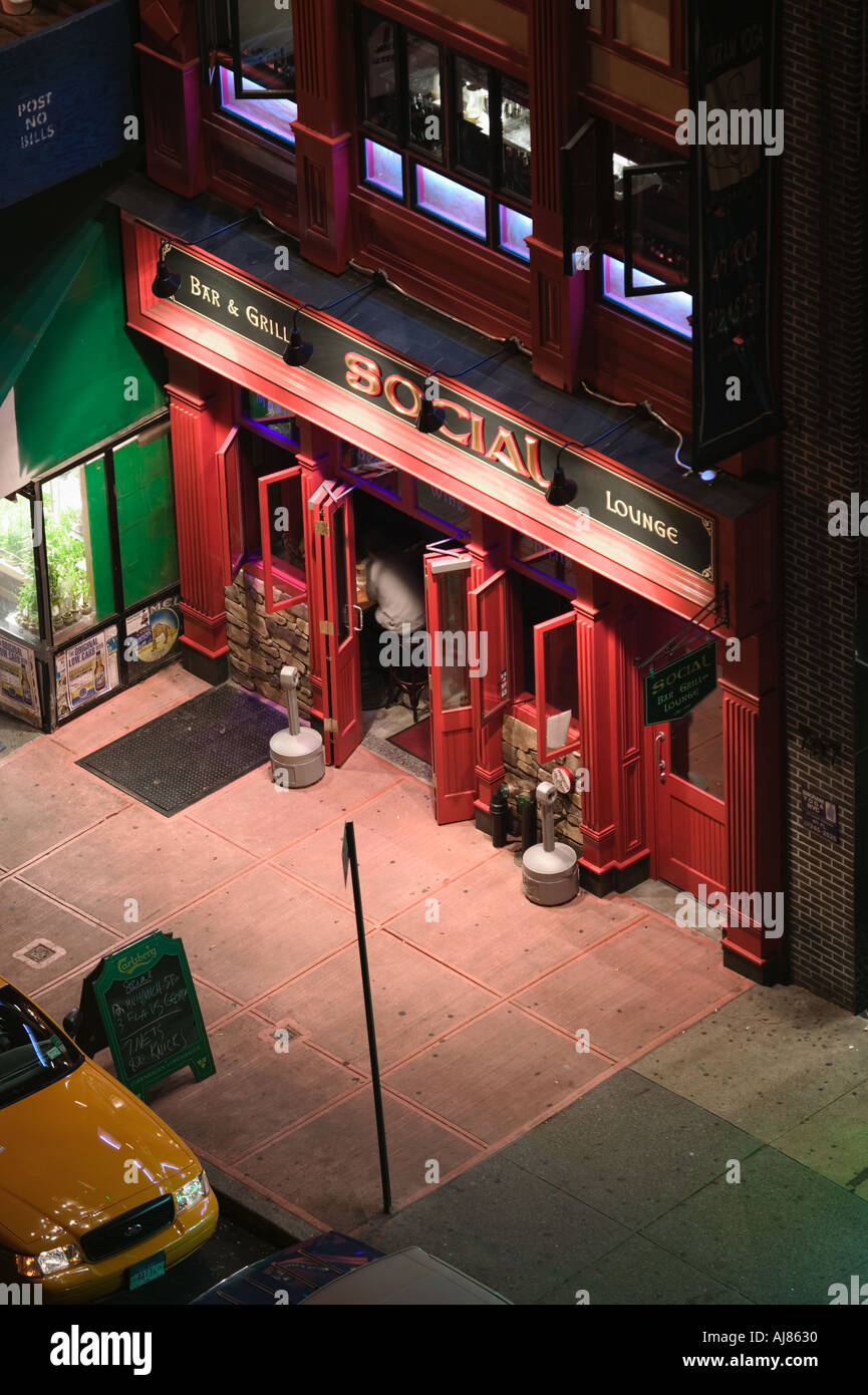 Taxi parkte am Straßenrand in der Nähe von Eingang der sozialen bar Grill-Restaurant an der Eighth Avenue 48th Street in Midtown Manhattan neue Stockfoto