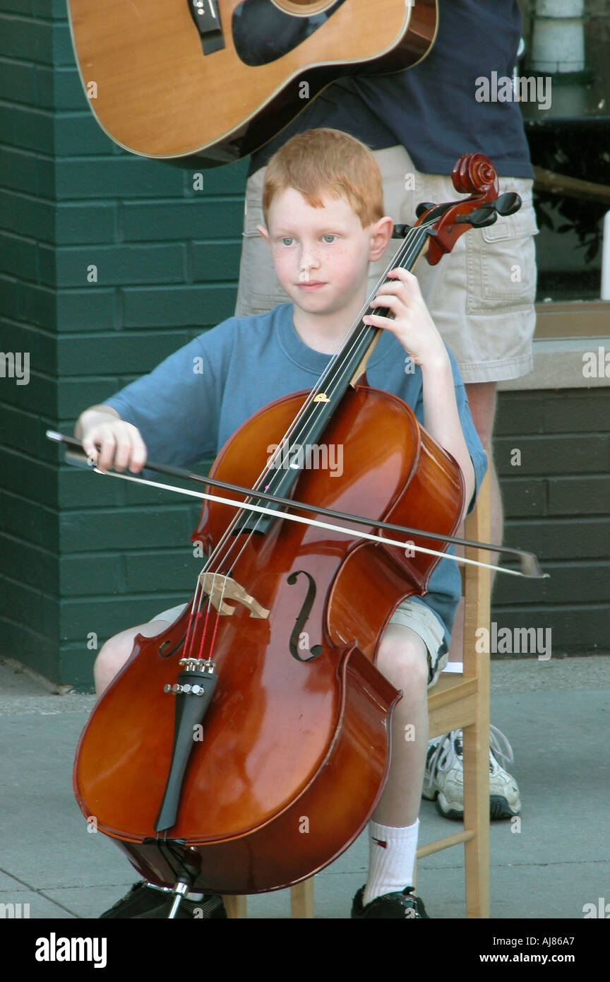 Männliches Kind spielt Basis Geige bei Outdoor-Konzert Stockfoto