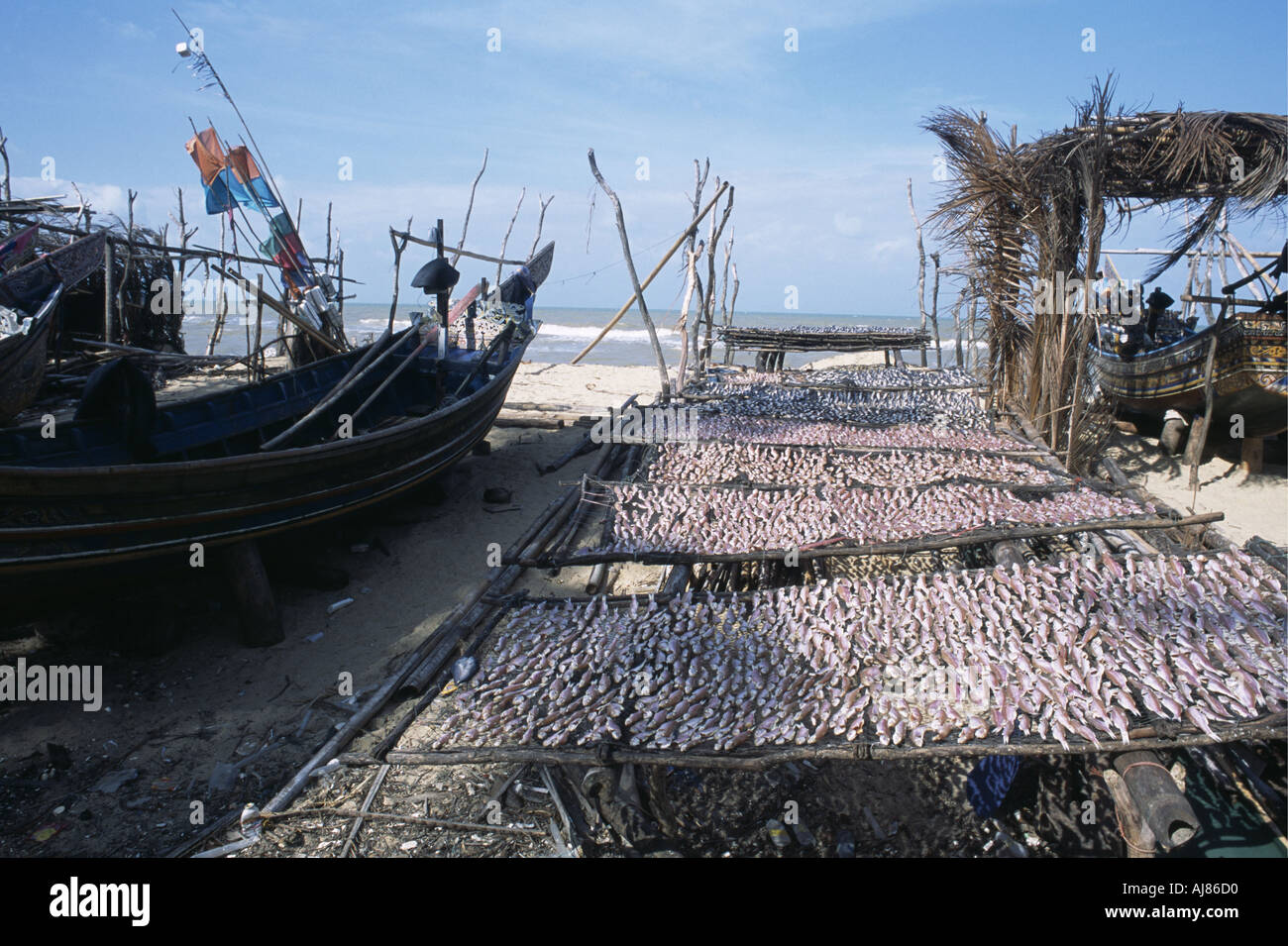 Korlae Boote an einem hölzernen Pier am Buri Fisch trocknen im Vordergrund Thailand Stockfoto