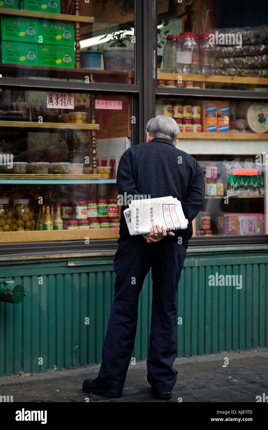 Mann Schaufensterbummel bei China Food Import Corporation an Ecke von Lafayette und Grand New York NY Stockfoto