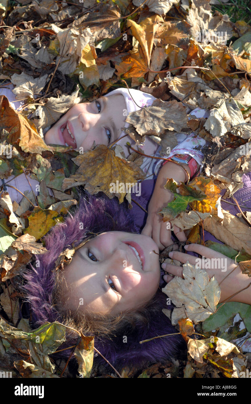 Herbst, Kinder spielen unter Autumn Leaves, England, UK Stockfoto