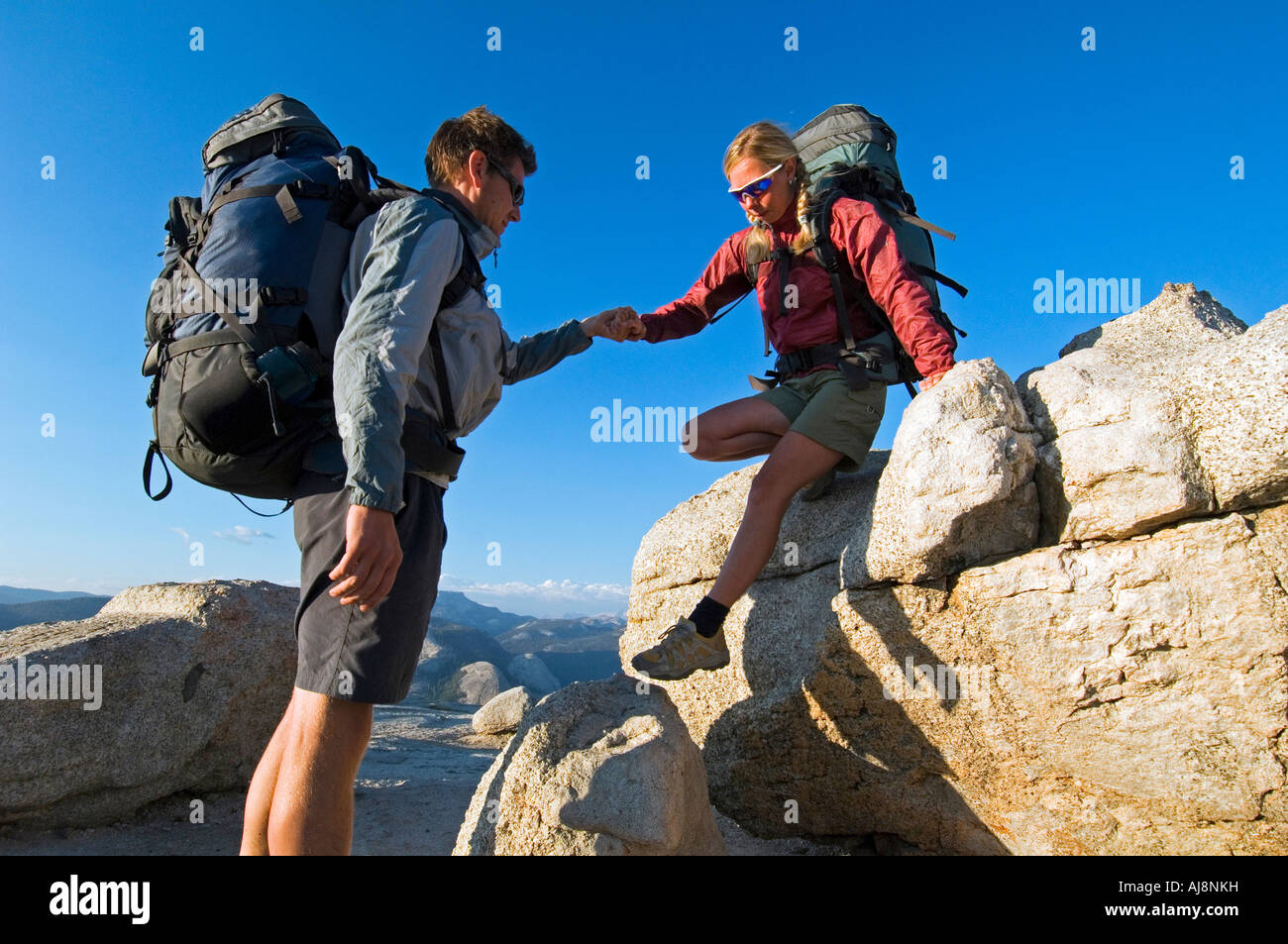 Wanderer aus Fels geholfen wird. Stockfoto