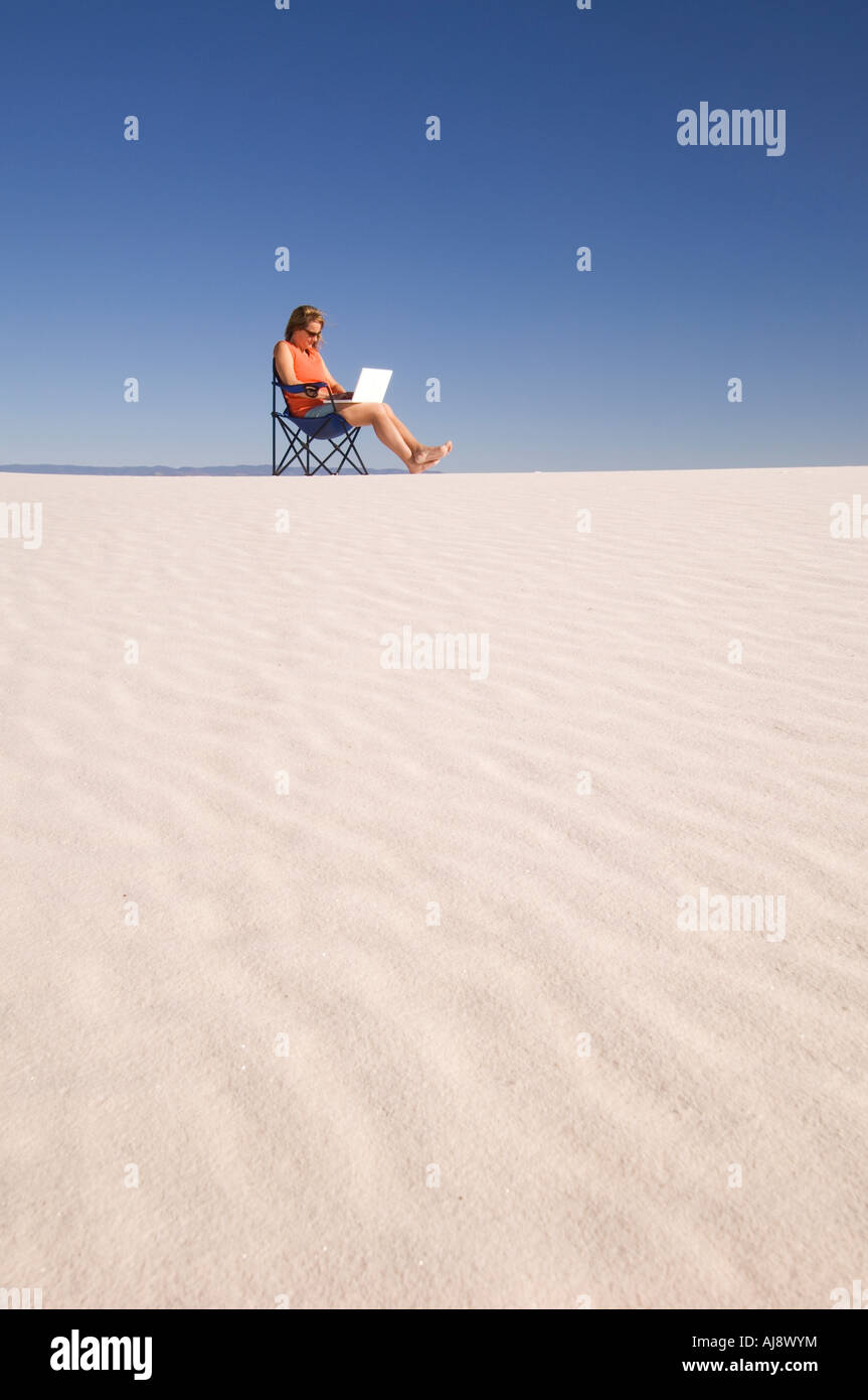 Frau mit Laptop in den Sanddünen. Stockfoto