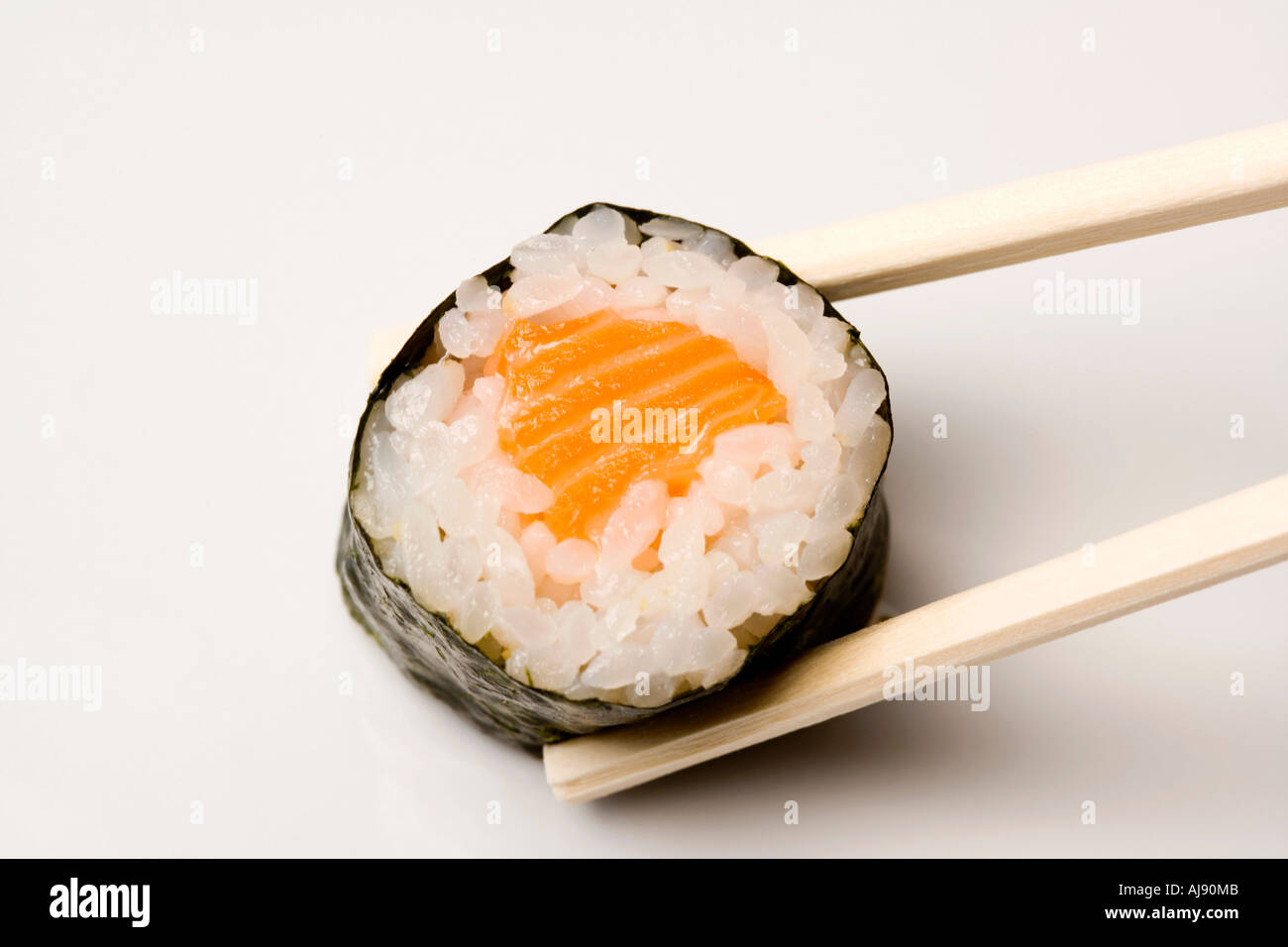 Hölzerne Stäbchen mit Lachs Sushi-Stück Stockfoto