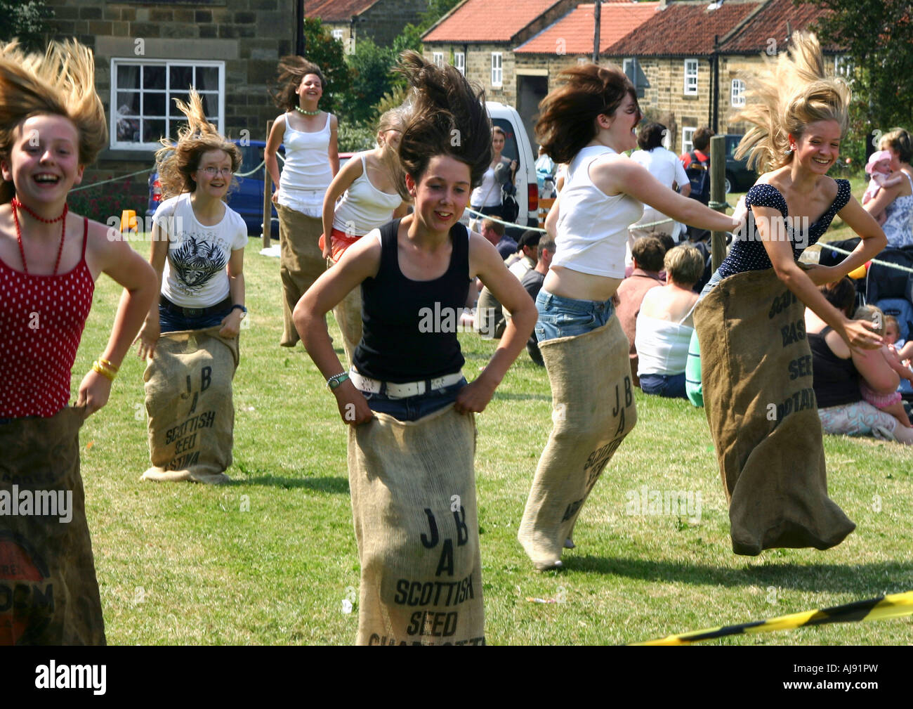 Mädchen im Teenageralter im Sackhüpfen Osmotherley Dorf Spiele, Yorkshire, England Stockfoto
