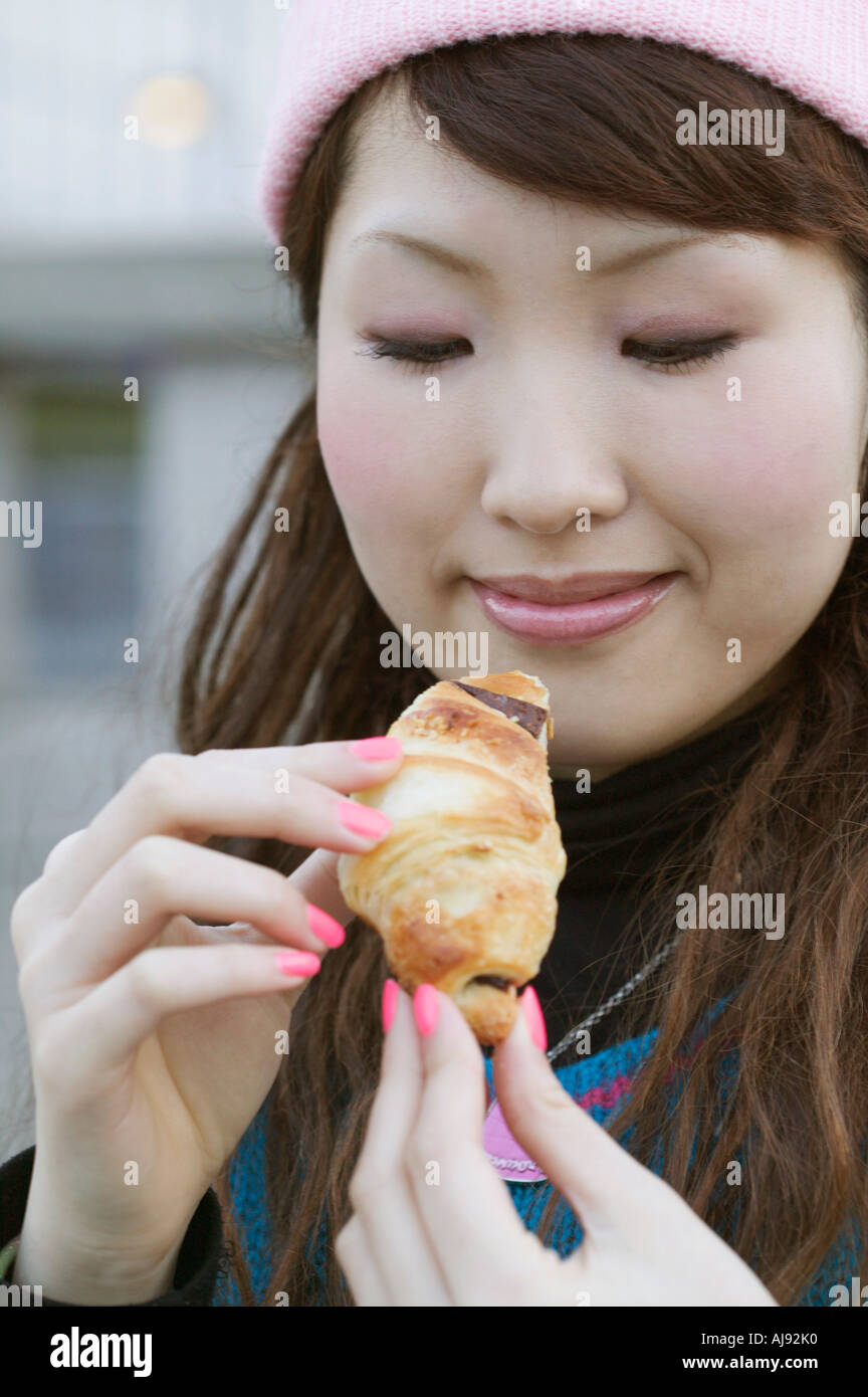 Junge Frau Holding Schoko croissant Stockfoto
