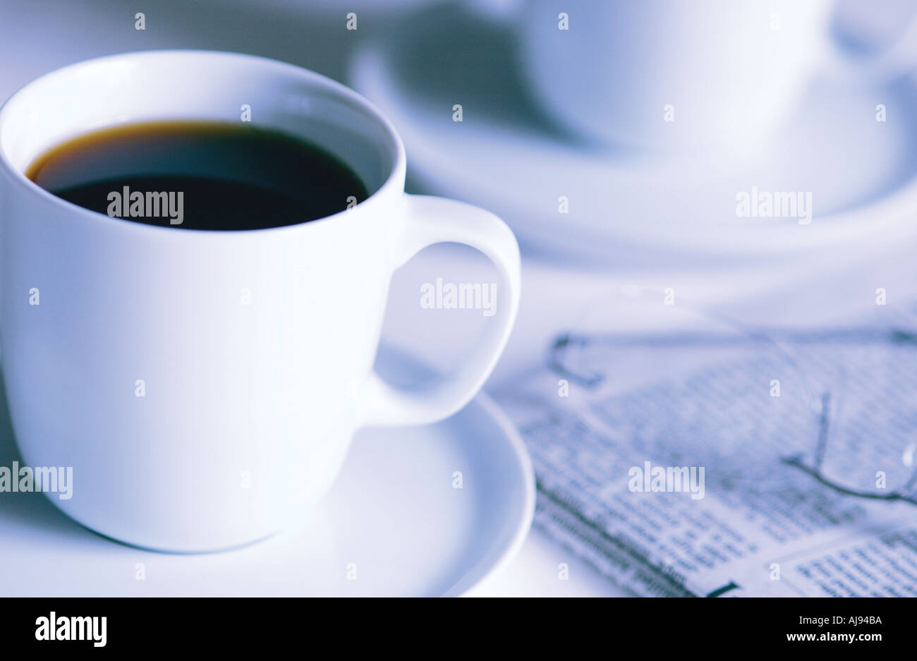 Nahaufnahme von schwarzem Kaffee in Tassen Tasse mit einer Zeitung Stockfoto