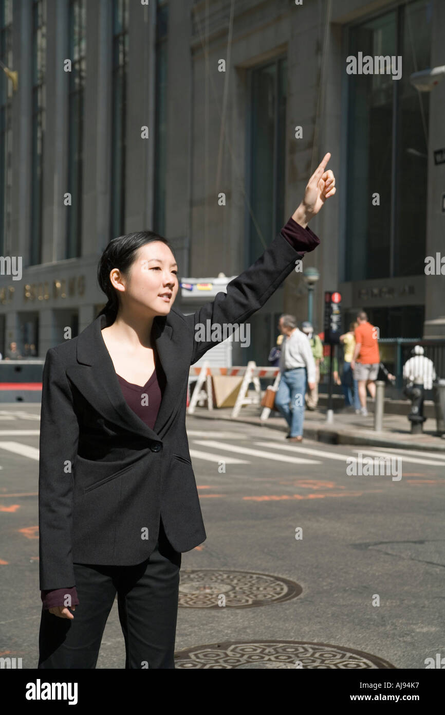 Junge Geschäftsfrau stehen auf Straße hagelt taxi Stockfoto
