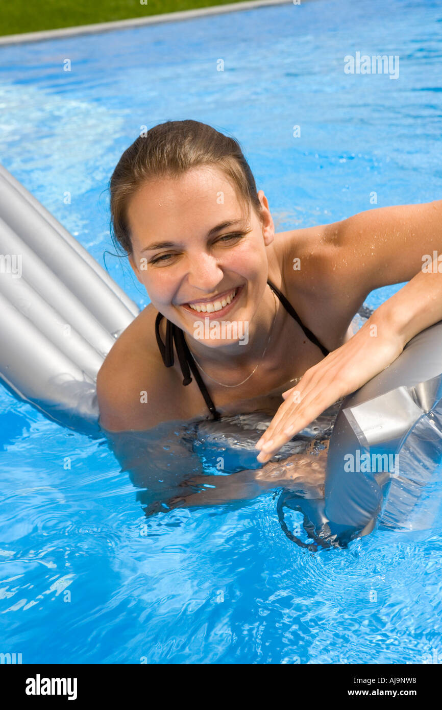 Eine junge Frau auf einem Schlauchboot im Pool Spielen Stockfoto