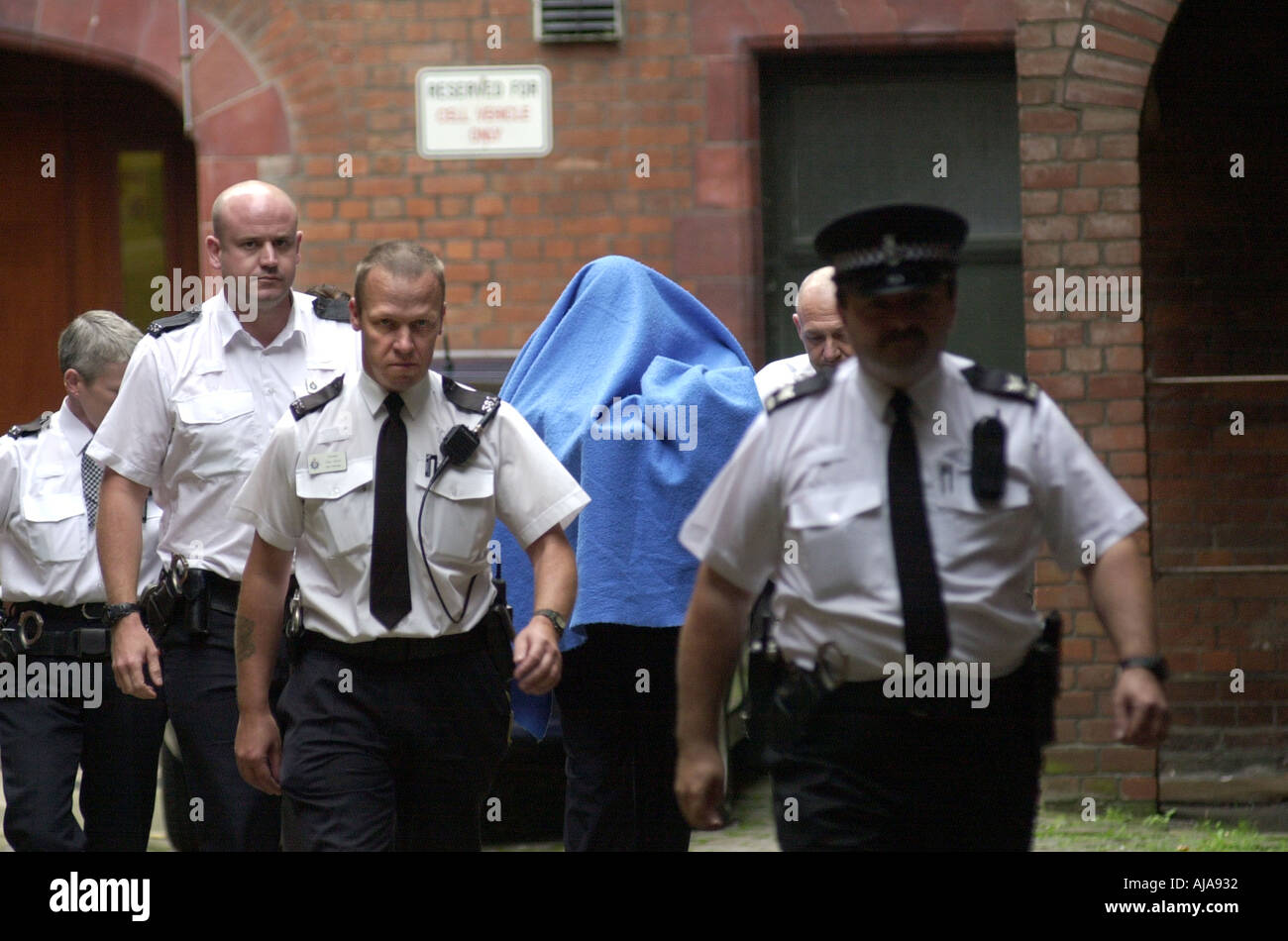 Angeklagten geht von einem Amtsgericht mit einer Polizeieskorte UK Stockfoto