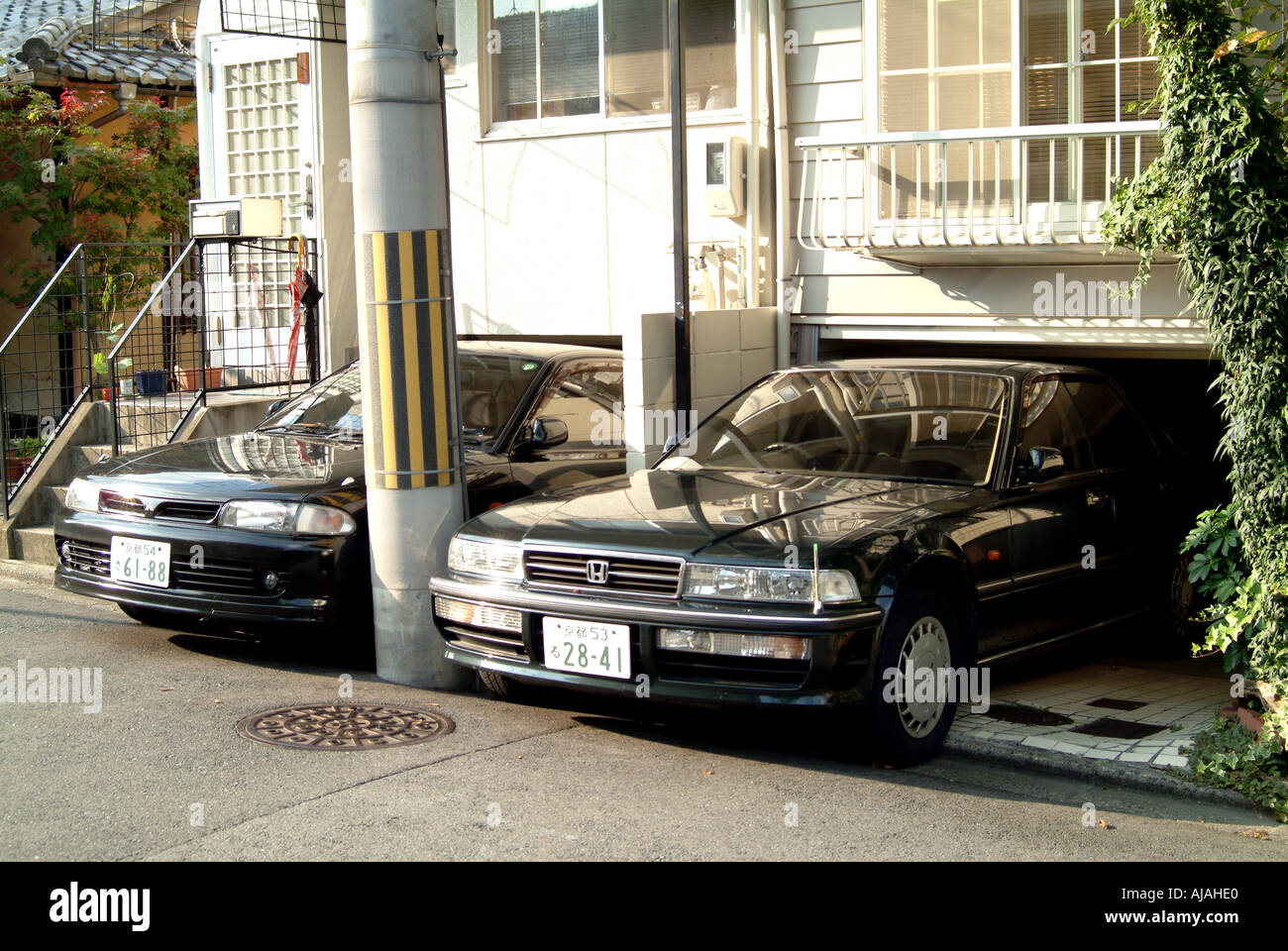 Autos in niedrigen Garagen unter Häuser Kyoto Japan Stockfoto