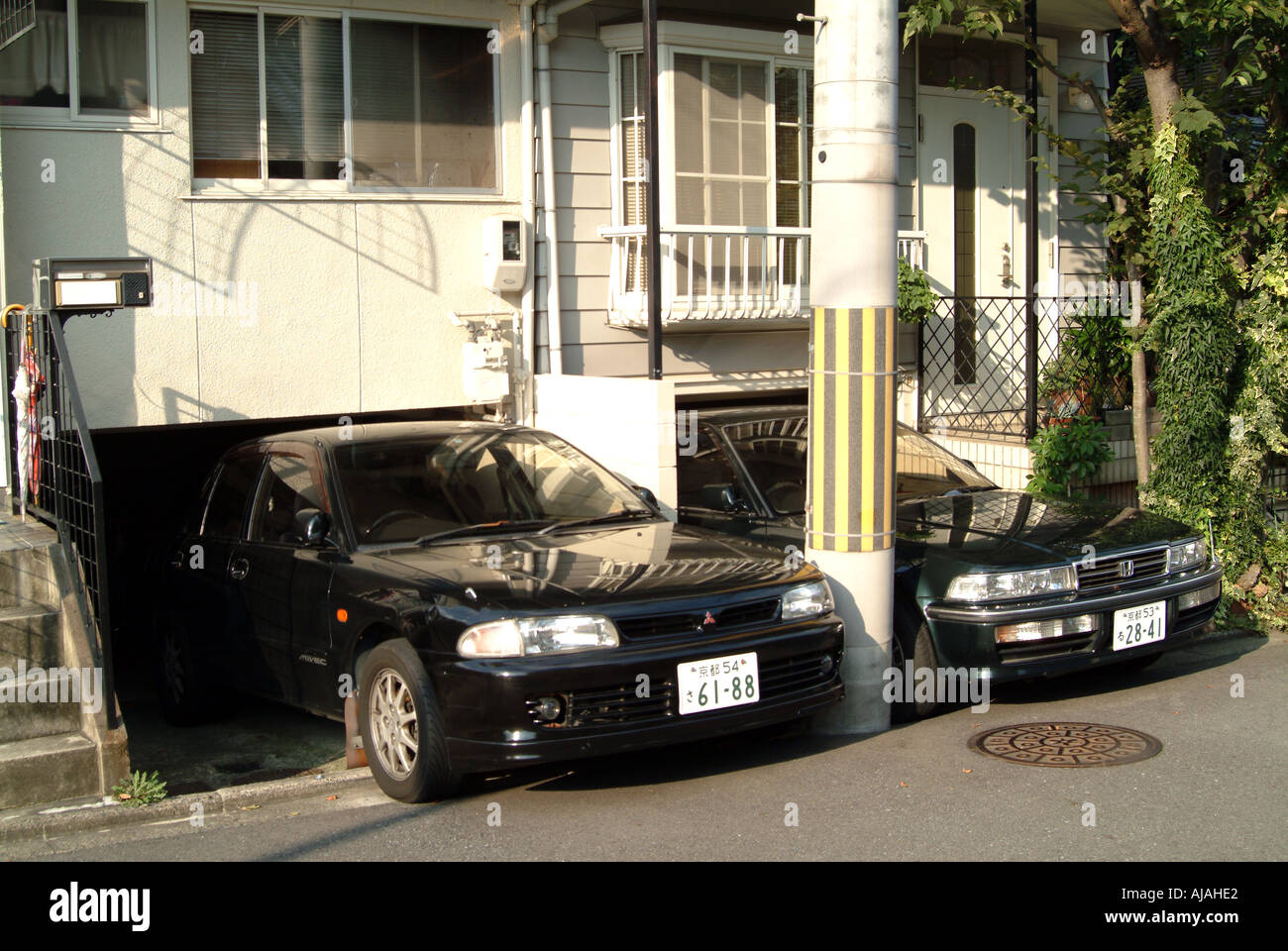 Autos in niedrigen Garagen unter Häuser Kyoto Japan Stockfoto