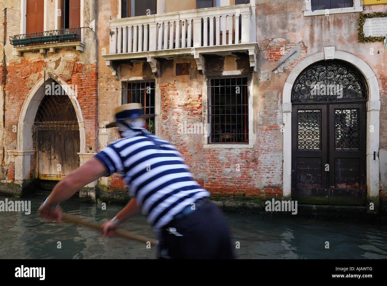 Verschwommene arbeiten Gondoliere Rudern in gestreiften Hemd Rudern auf einem Kanal in Venedig Italien Stockfoto Verschwommene arbeiten Gondoliere Rudern in gestreiften Hemd Rudern auf einem Kanal in Venedig Italien Stockfoto