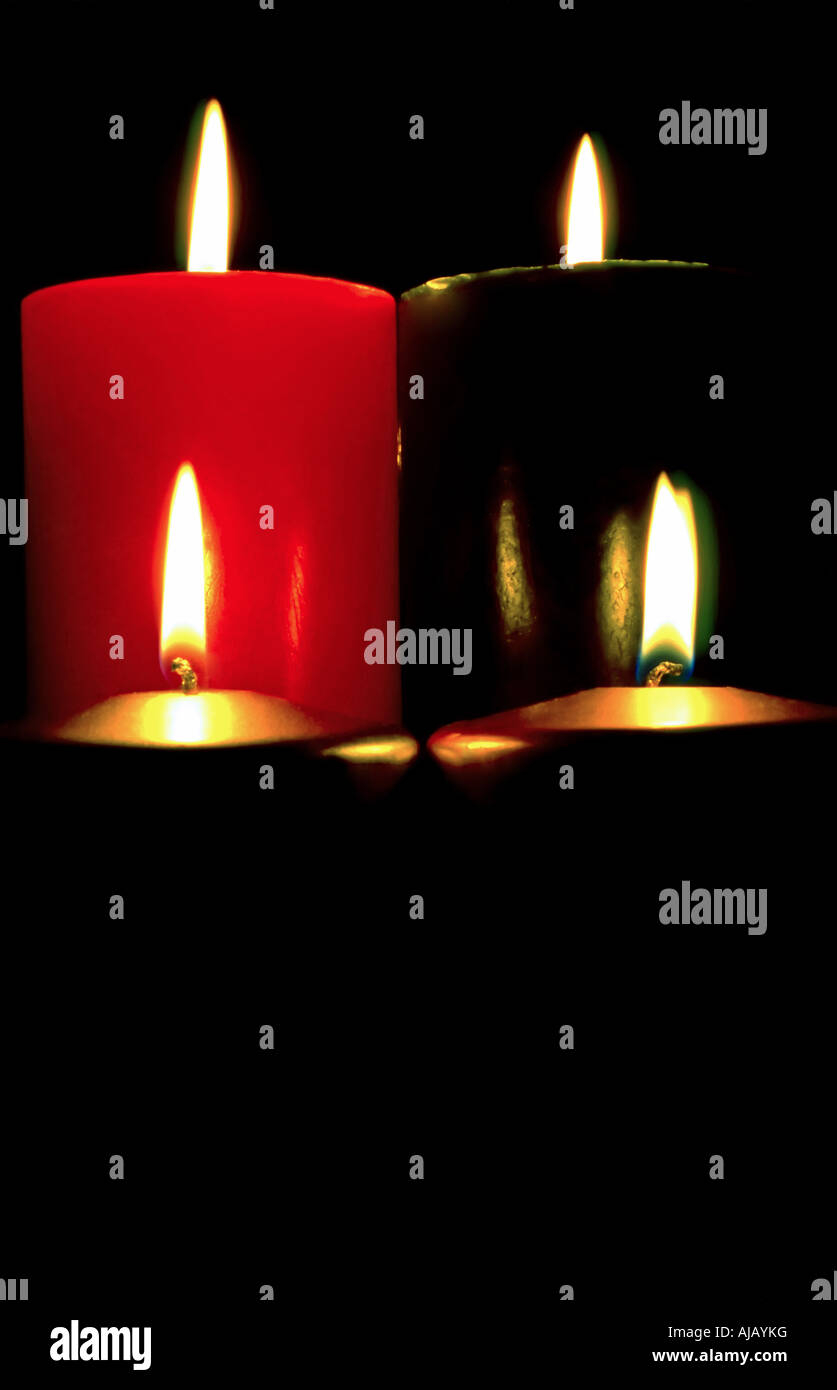 Schossen enge rot, grün, Gold und Silber Weihnachtskerzen brennen in einem abgedunkelten Raum. Stockfoto
