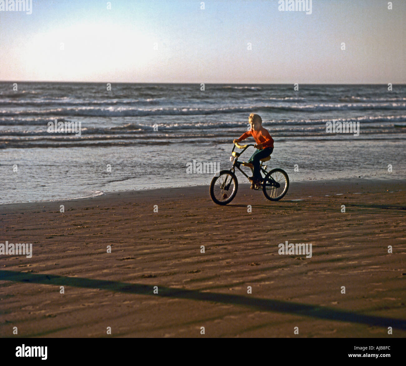 Radfahren am Sandstrand ein kleiner Junge selbst an der Central Oregon Coast genießt Stockfoto